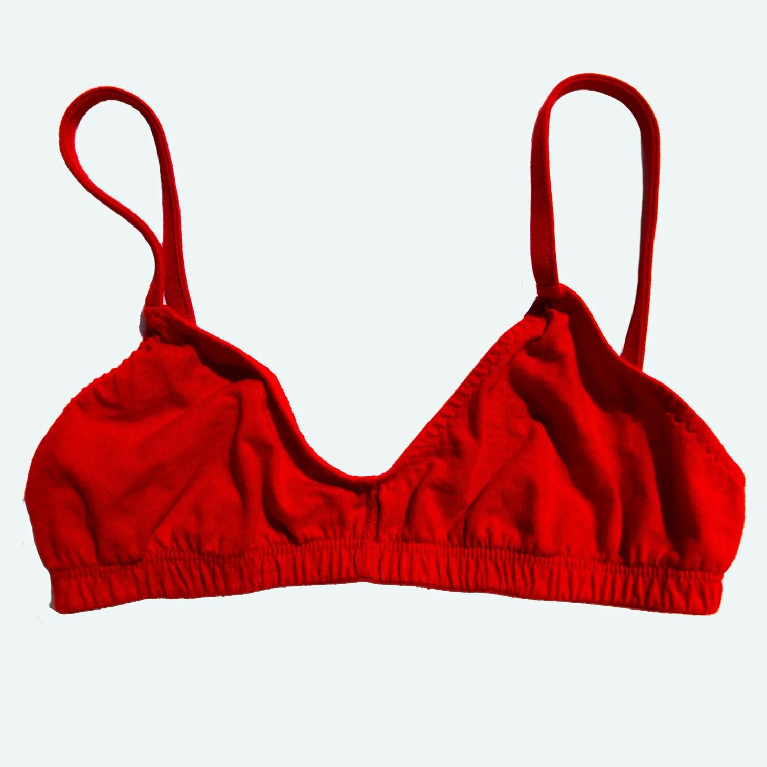 A flat product photograph of a Pansy organic cotton bra in red viewed from the front
