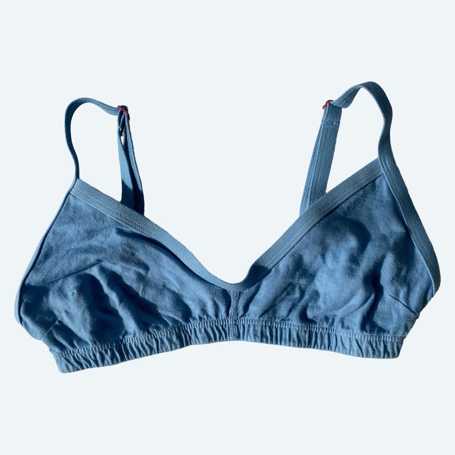 Front view of the Pansy organic cotton Smile Bra in Sky blue, laid flat with adjustable straps.