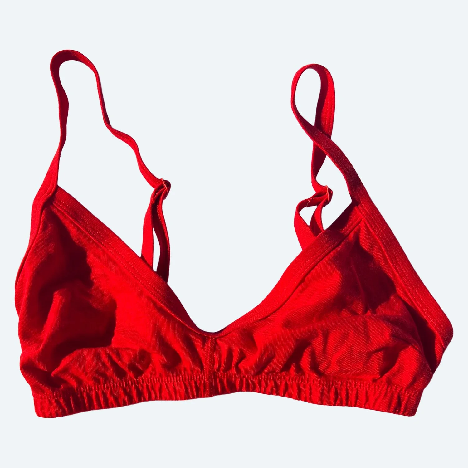 Front view of the Pansy organic cotton Smile Bra in Red, laid flat with adjustable straps.