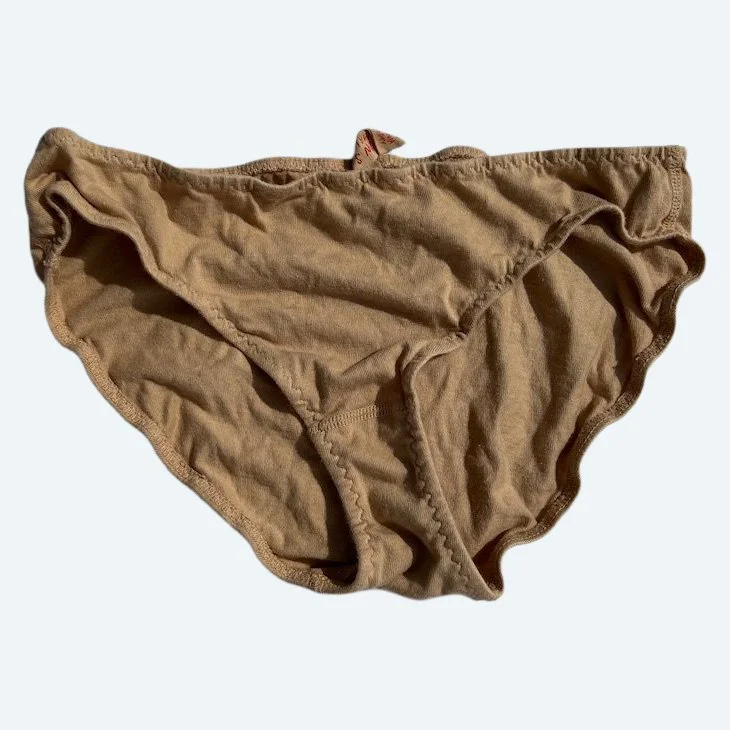Flat lay of Pansy low rise underwear in sand on a pale blue-gray background.