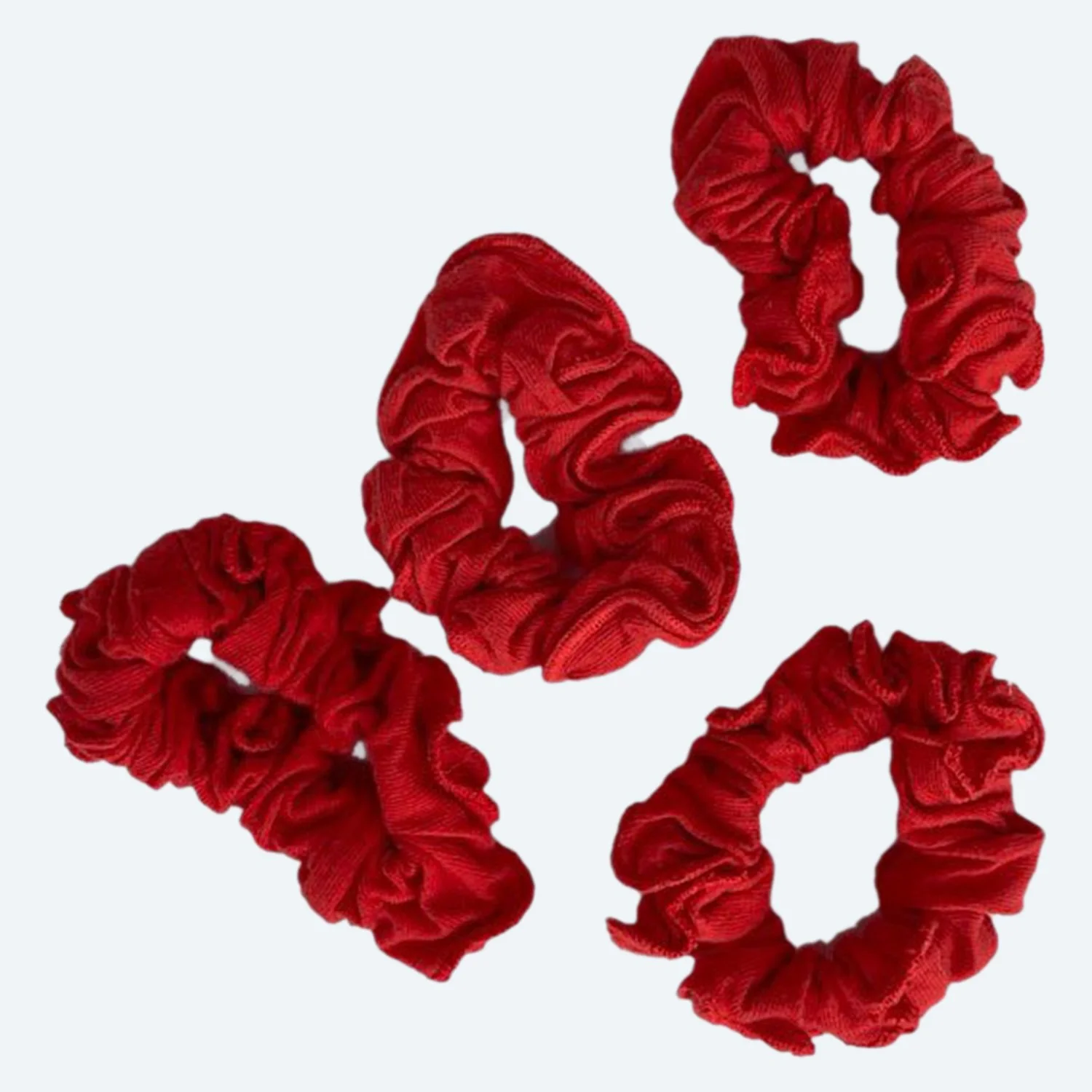 Four Pansy organic cotton scrunchies in Red, laid flat.