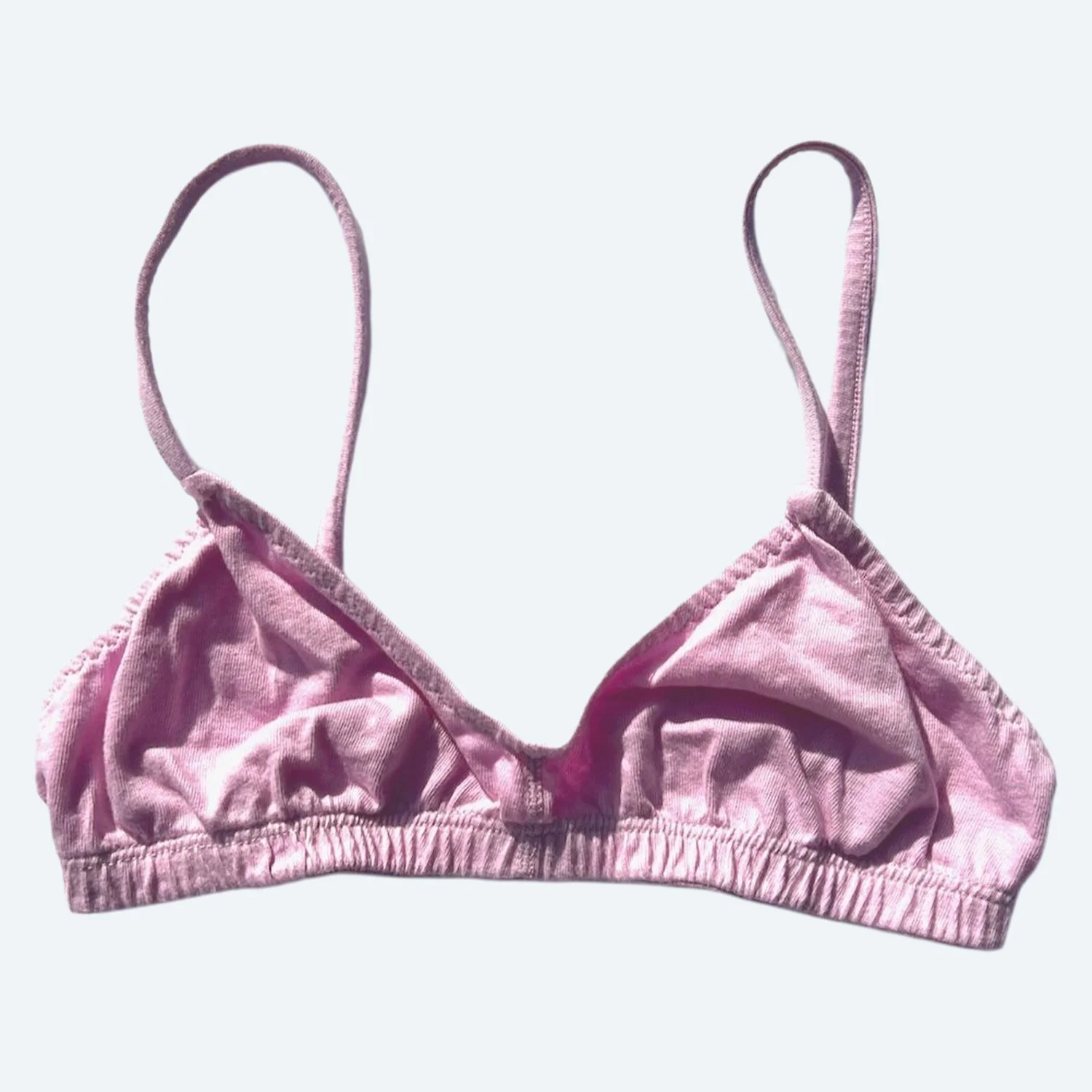 Front view of the Pansy organic cotton Bra in Blossom pink, laid flat with thin straps and a gathered underband.