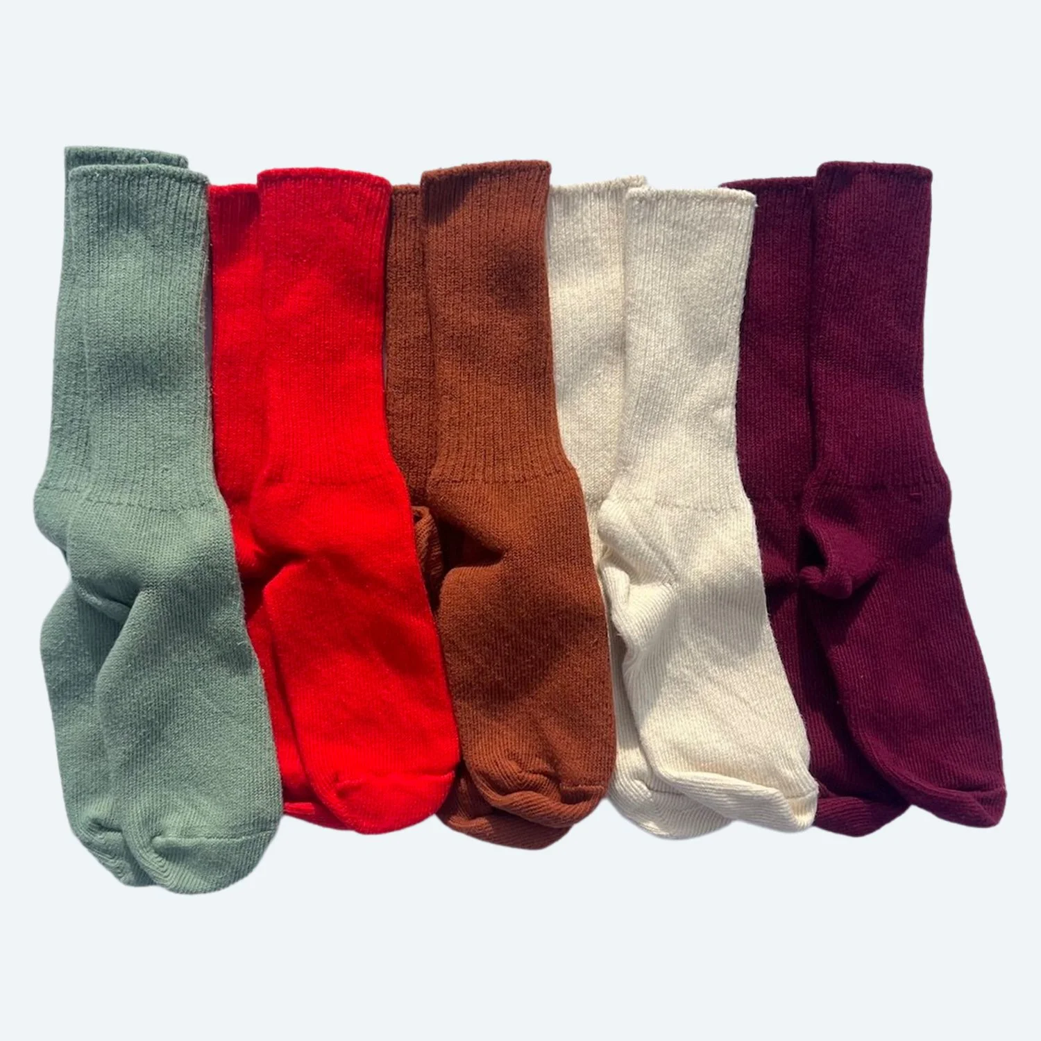 Pansy organic cotton crew socks in Mermaid green, Red, Rust brown, Natural cream and Wine, arranged side by side.