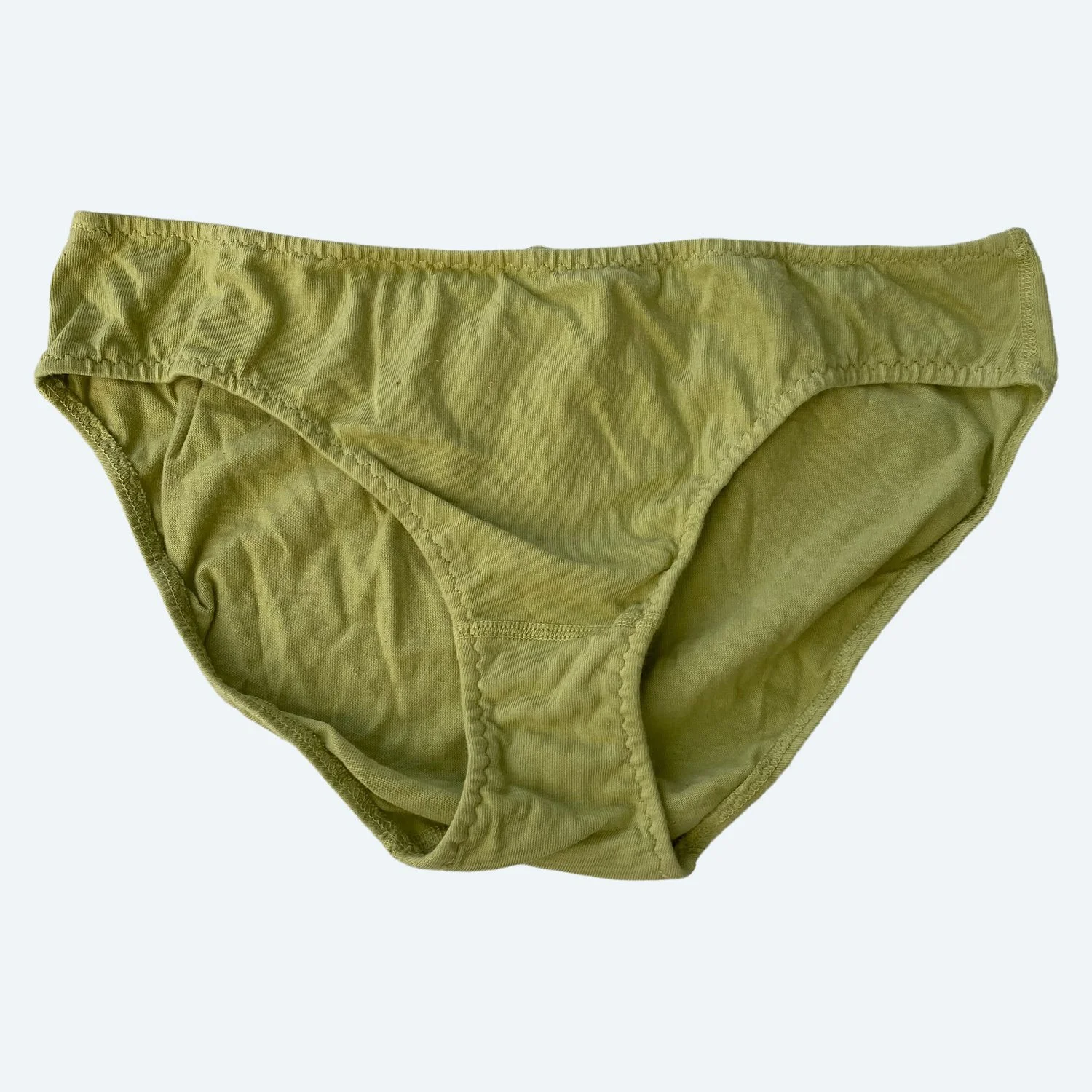 Flat lay of Pansy low rise underwear in avocado green on a pale blue-gray background.