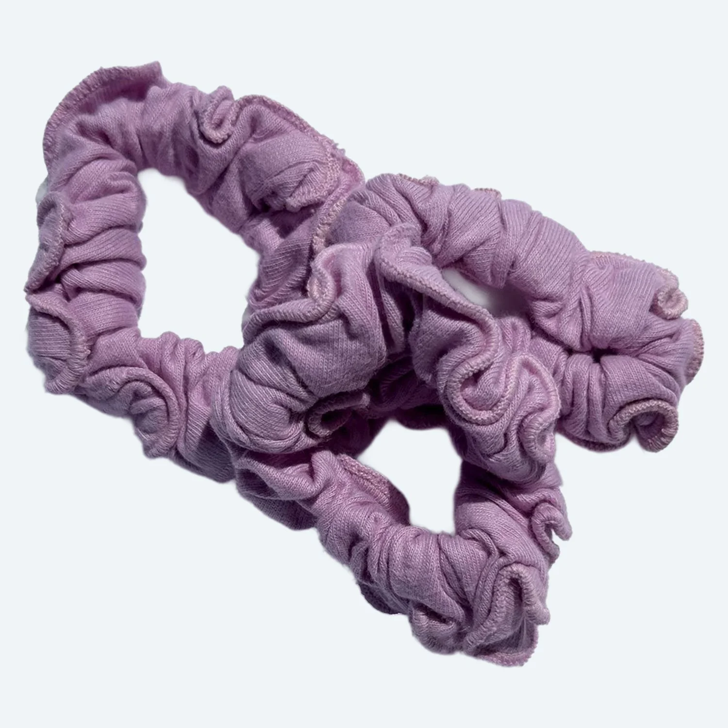 Two overlapping Pansy organic cotton scrunchies in Blossom pink.