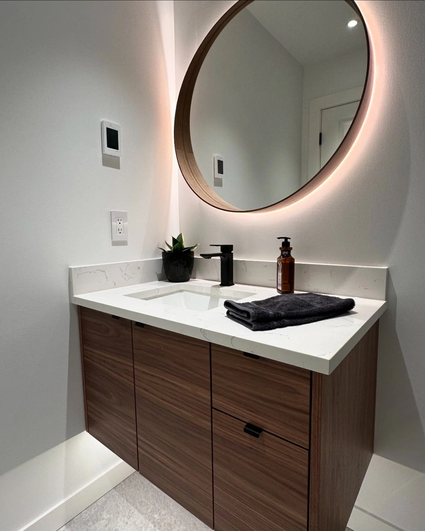 Just completed our Port Moody basement bathroom transformation! Check out this wall-mounted American Black Walnut vanity, featuring elegant under-cabinet accent lighting. The custom round backlit mirror adds the perfect finishing touch!
.
.
.
#revita