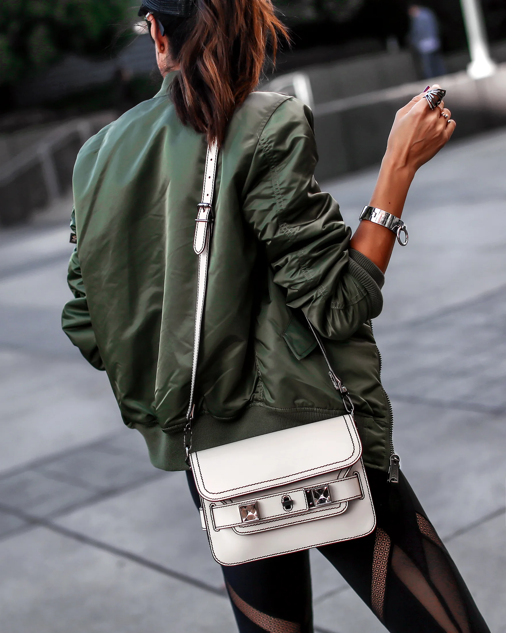 Brunette Woman Bomber Jacket and White Purse