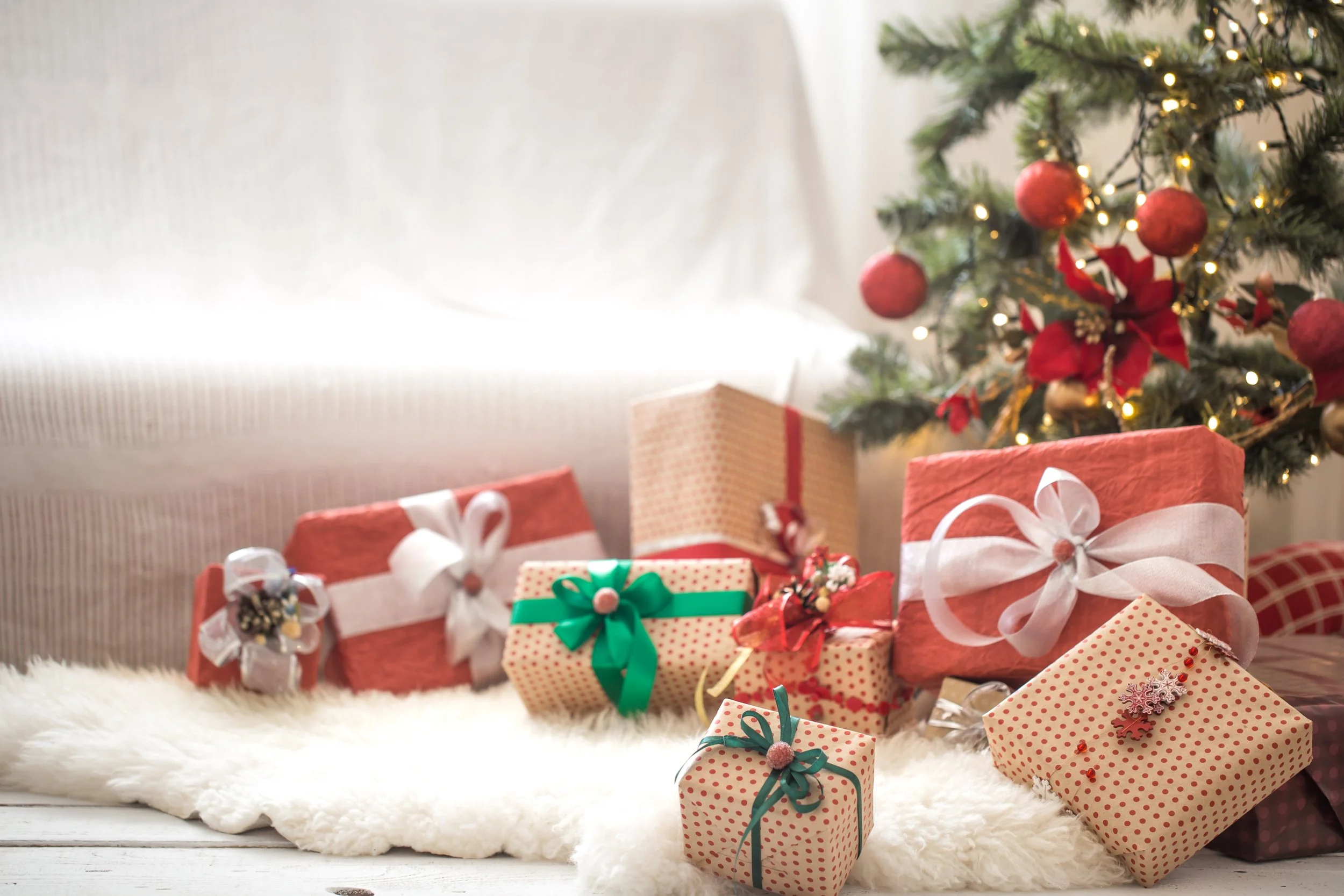 pile-christmas-presents-light-wall-wooden-table-with-cozy-rug-christmas-decorations.jpg
