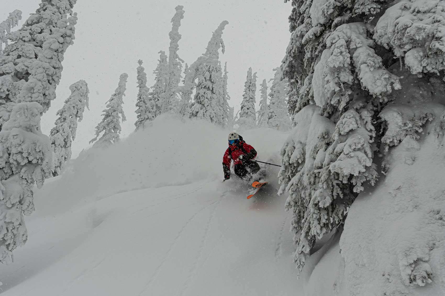 Skier on a guided ski tour of the Powder Highway in British Columbia in deep powder.