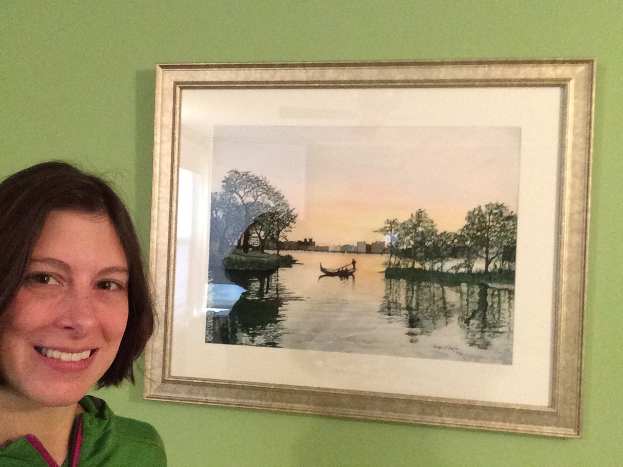 Laura with framed painting on her wall