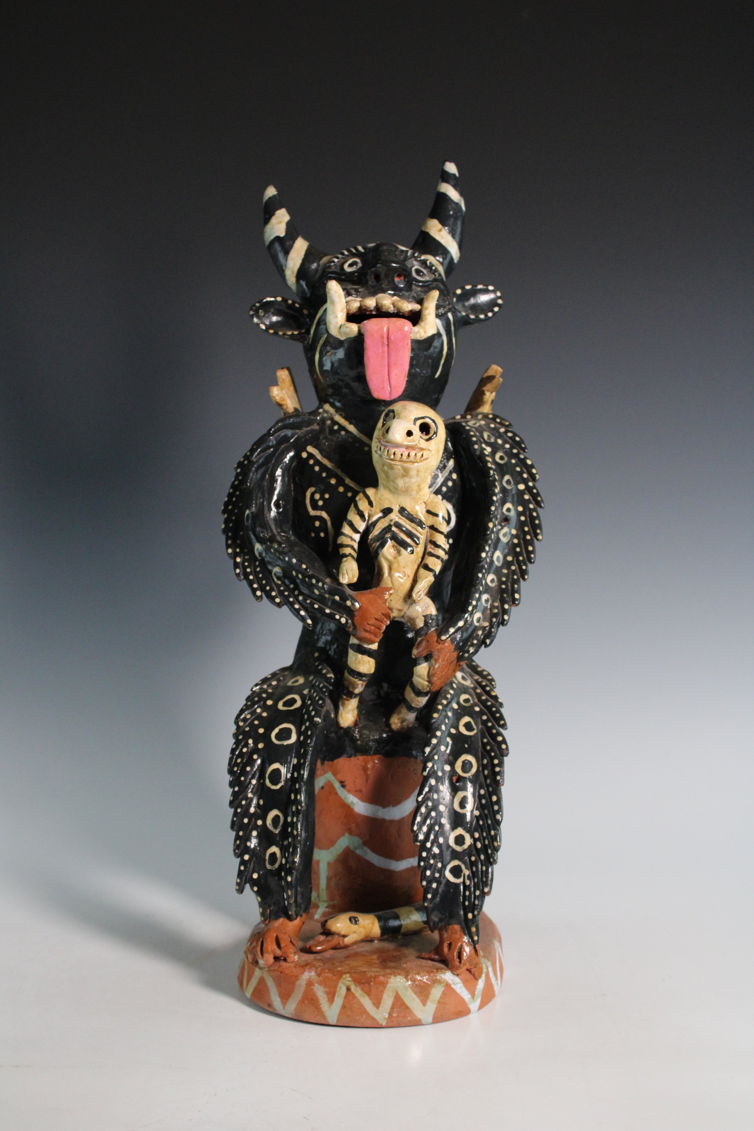 Mexican Folk Art Polychrome Earthenware Sculpture Featuring a Winged, Horned Devil Holding the Dead, 20th Century