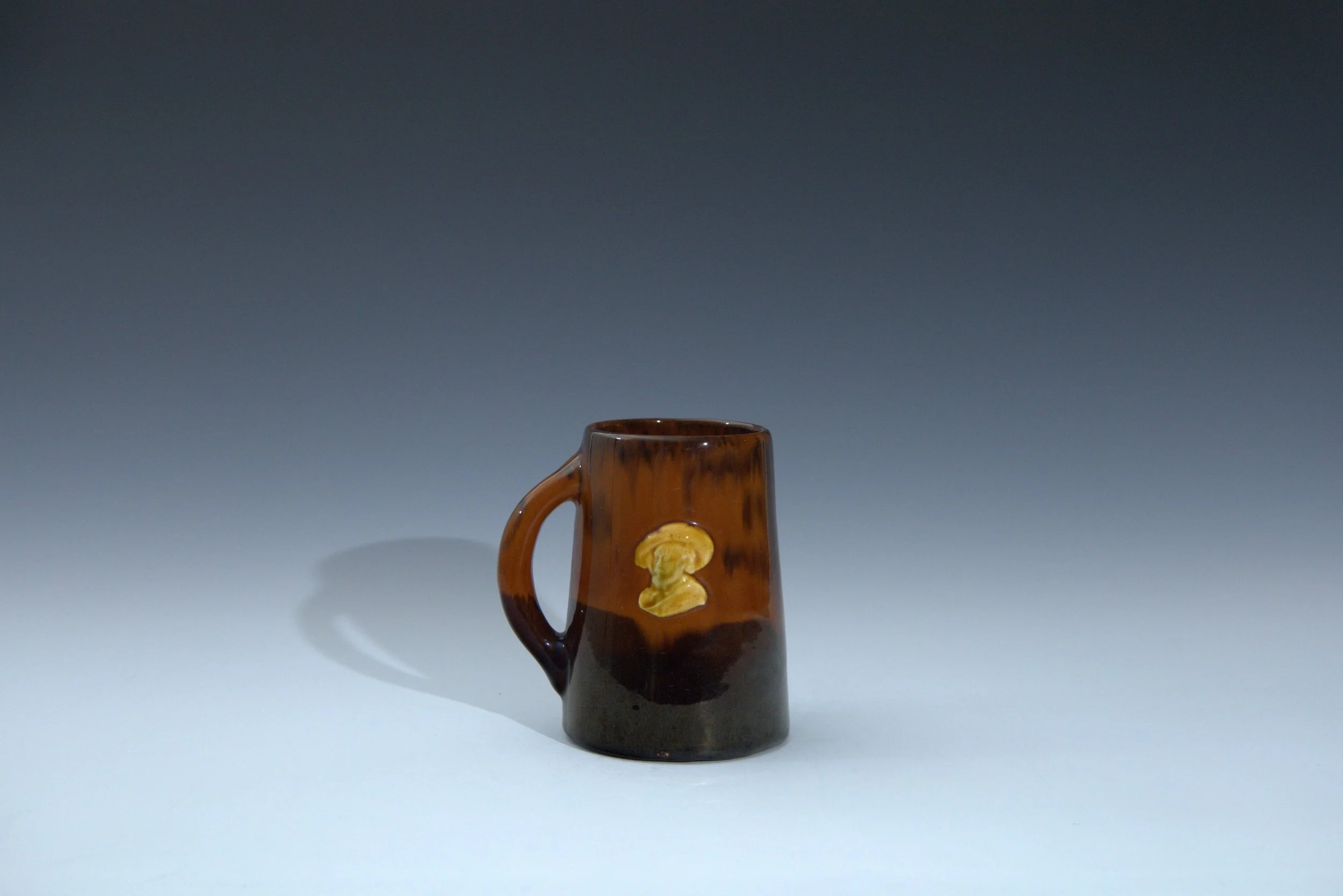 Weller Pottery Company (1872-1948), Sprigged Ware Line Mug Featuring a Portrait of a Cavalier, decorated by Albert E. Radford (1859-1904), 1898-1900, earthenware. 2023.012.008