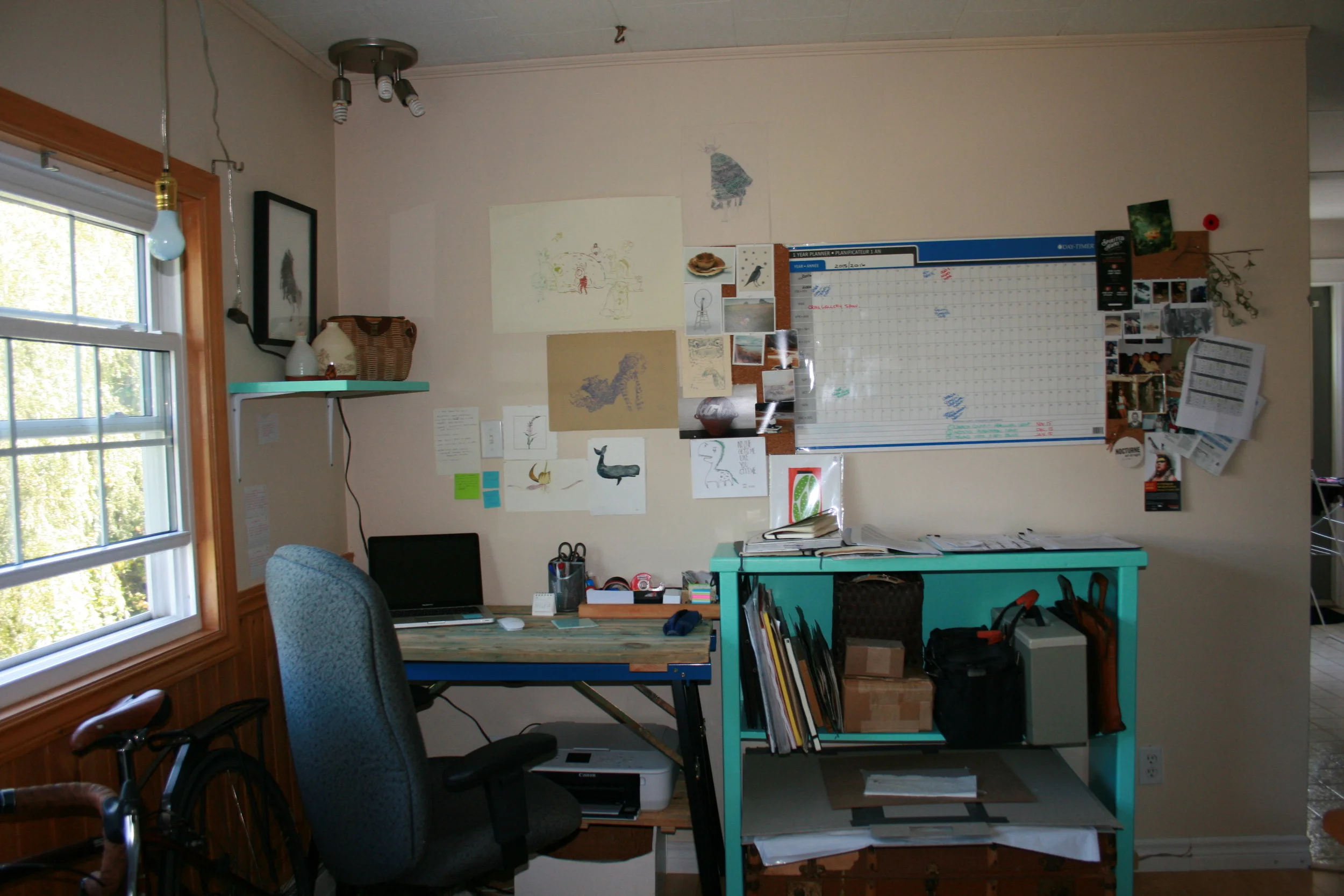 This is my writing and planning space. All the images on my wall are pictures of family and friends and works by my friends who keep me inspired. 