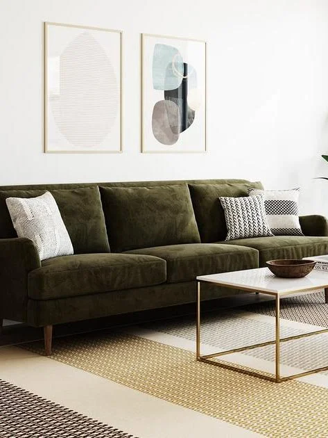 eco-friendly furniture - medley - made-to-order green velvet couch with throw pillows in a living room, on a striped rug with a gold and marble coffee table and gold framed prints