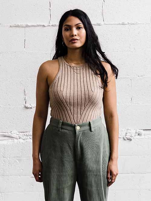 Eco-Friendly Clothing Brands: Model wears Soluna Collective's cremini oyster-colored top paired with a sage-green pair of pants.