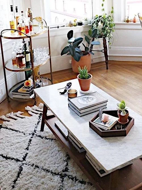 eco-friendly furniture - etsy reclaimed furniture - reclaimed coffee table in a living room on top of a cross pattern rug and next to a bar cart and some plants