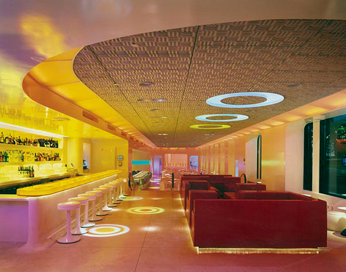  Front bar &amp; lounge - back-lit amber resin counter, lounge seating unit of red urethane foam, acoustic foam tiles for sound-absorbent ceiling, stairs in back with rubberized escalator handrails leading to main dining area 