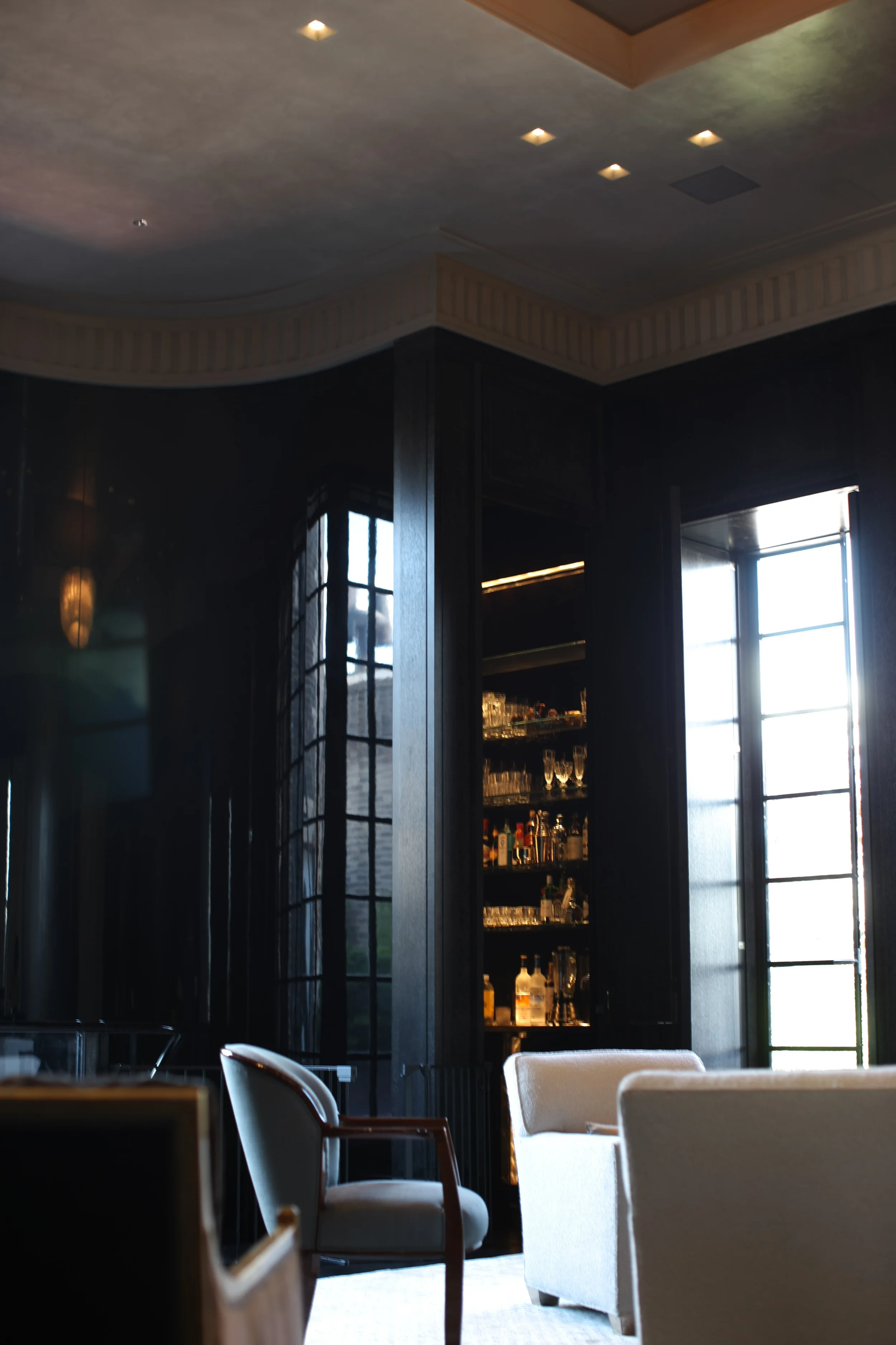 Wet bar - High gloss black lacquer wall panels and gilded ceiling