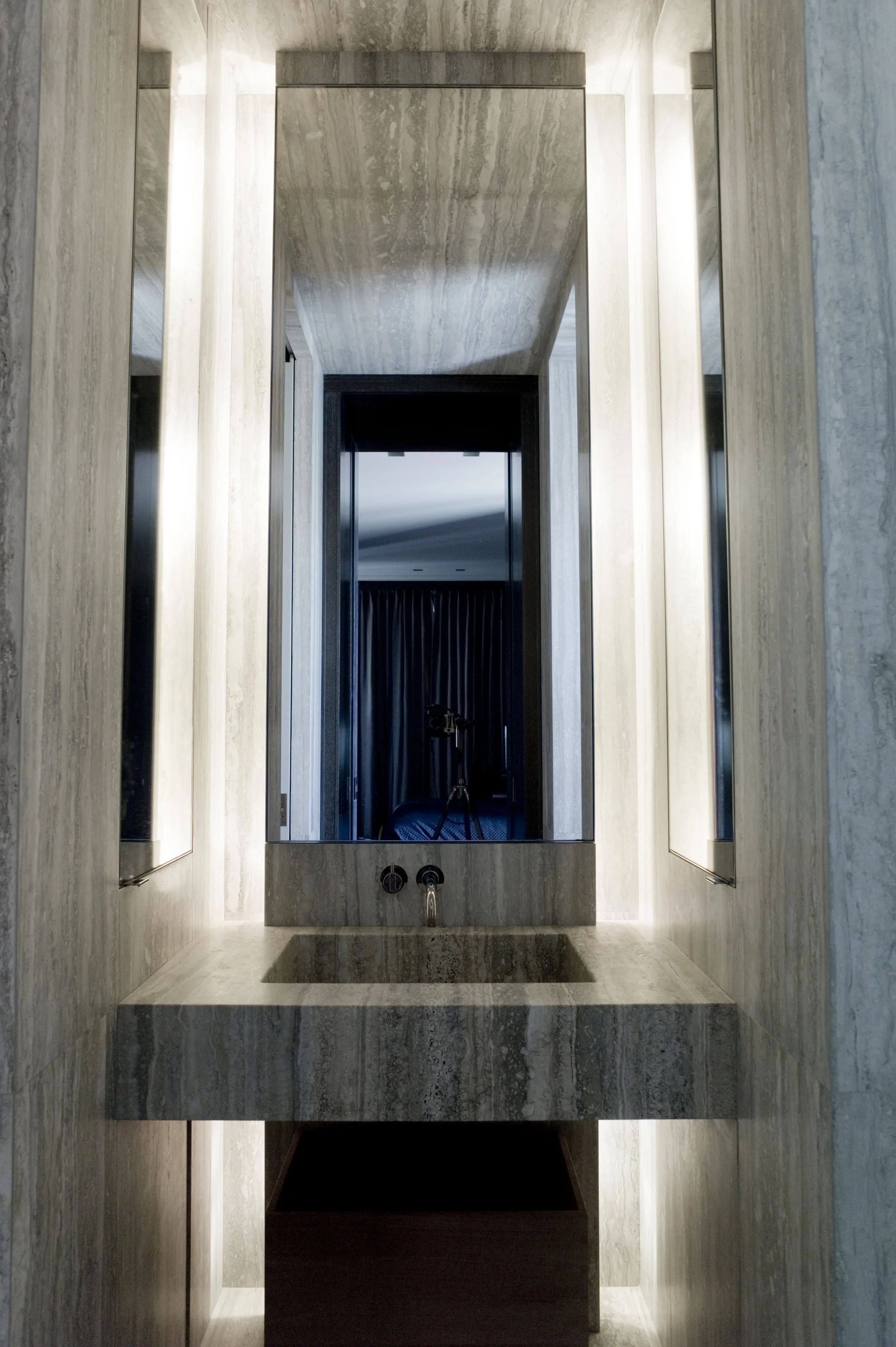 Vanity carved from silver travertine in guest bathroom
