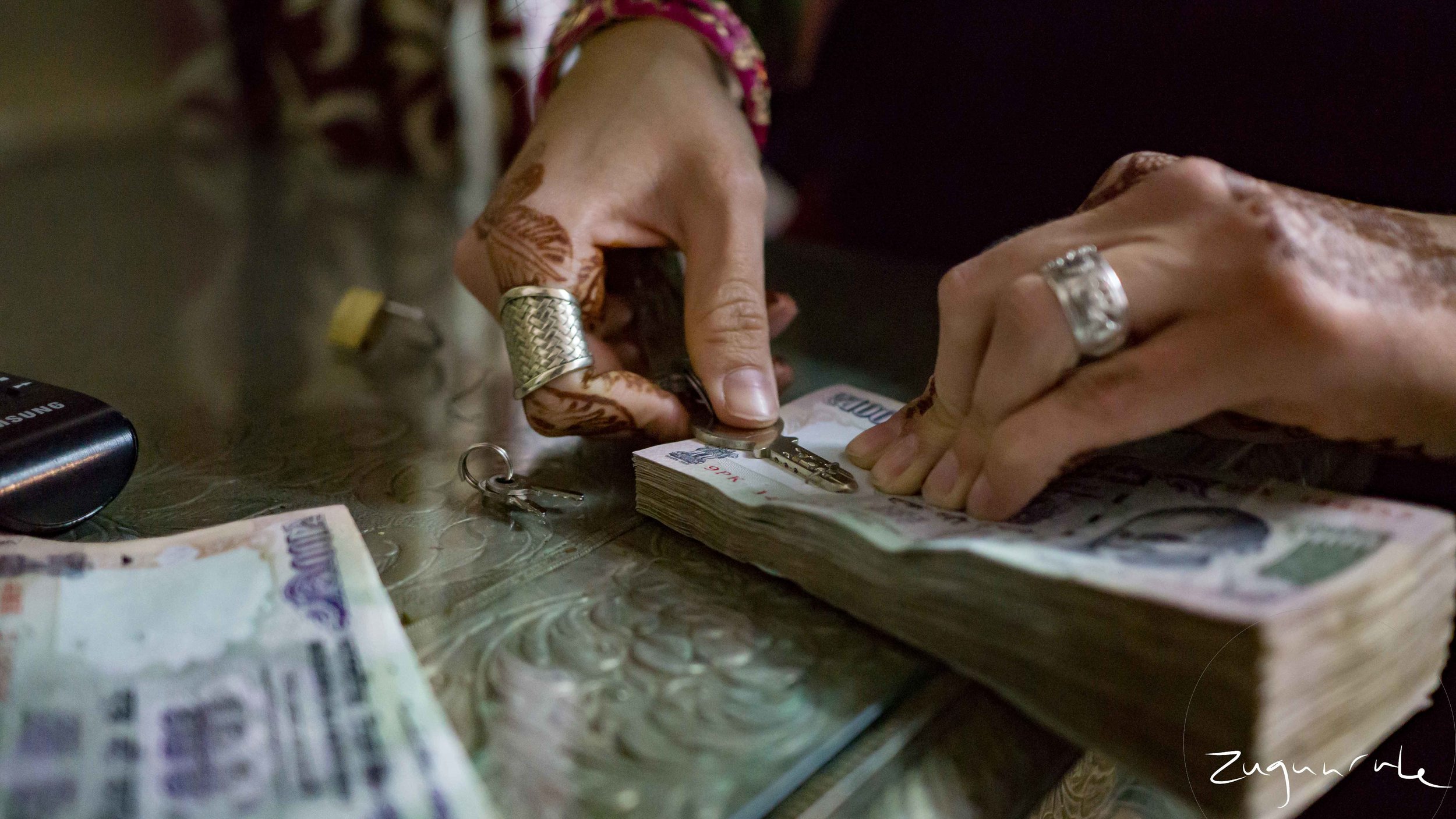 Removing the staple from our stacks of 100 rupee notes (Udaipur)
