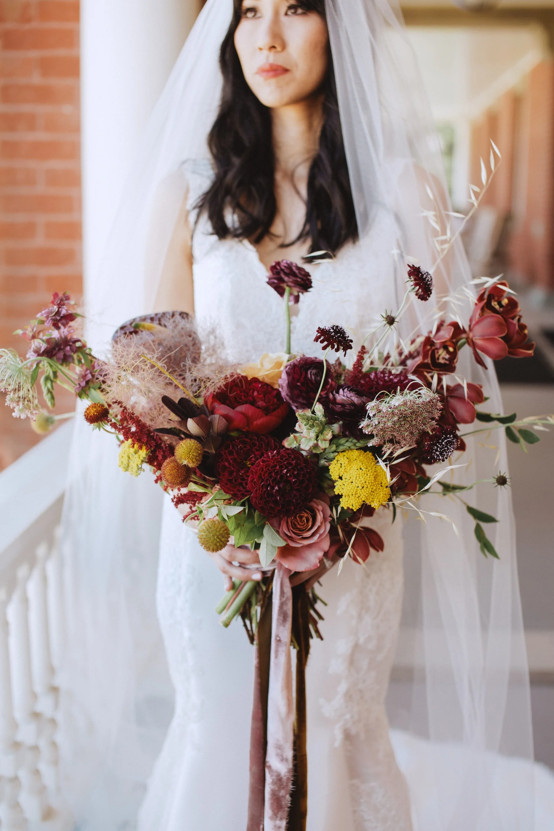 red and mauvey bridal style and bouquet inspo with silk velvet ribbons