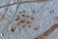Lenticulae: The odd reddish splotches in the center of this image may be the key to finding life on Europa. The splotches, or lenticulae, may represent areas of warm water from Europa's underground ocean. (Click to view larger image) Courtesy of Galileo Project, NASA