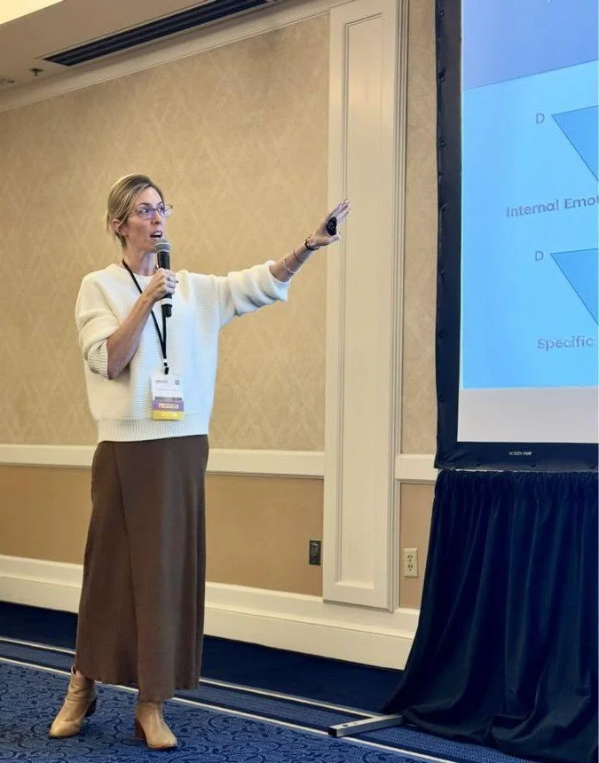 Michelle M. May presenting at a conference, previewing upcoming speaking events. Image by Nicole Ballez.