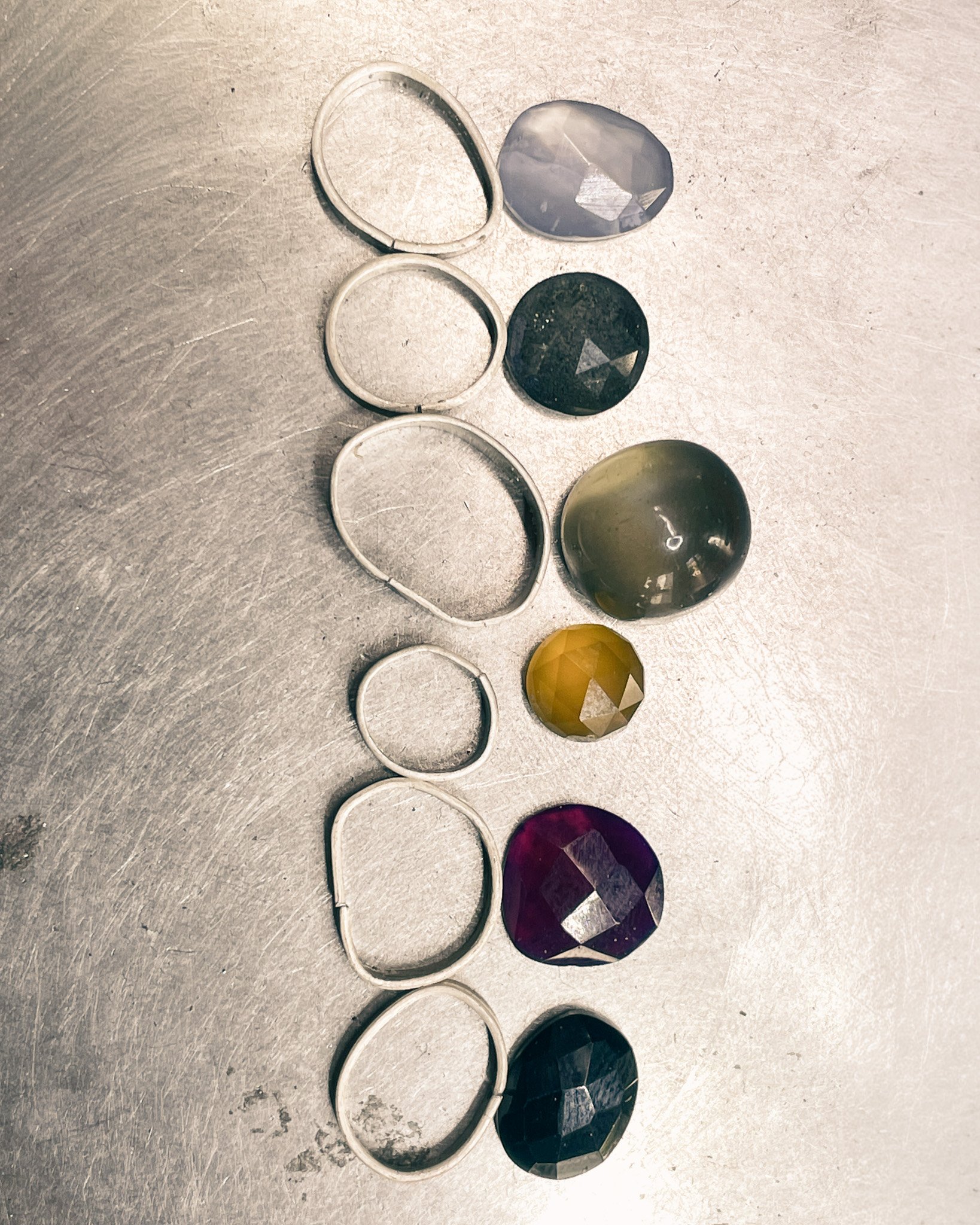 This image features pretty gemstones and silver bezels before they are made into pendants