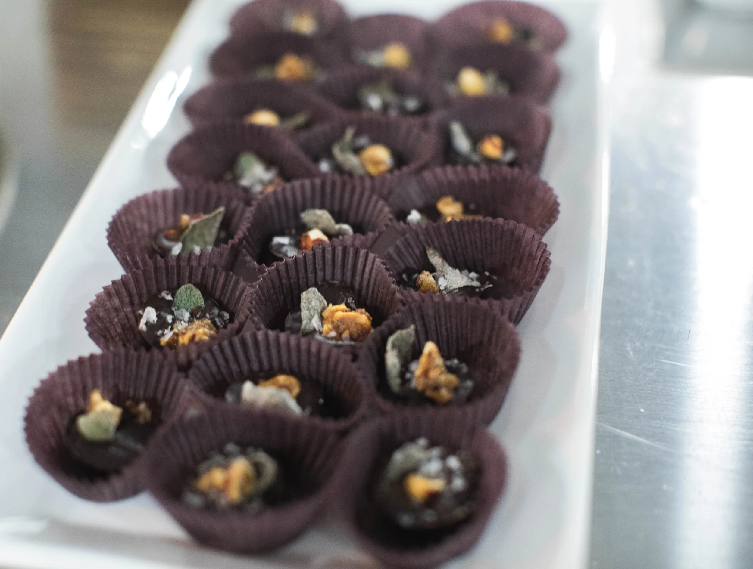 Flora + Fauna Autumn: sugared sage, candied northwest hazelnuts, and Maldon salt on discs of 70% ÖKO Caribe. Photo credit: Quiwaan Little
