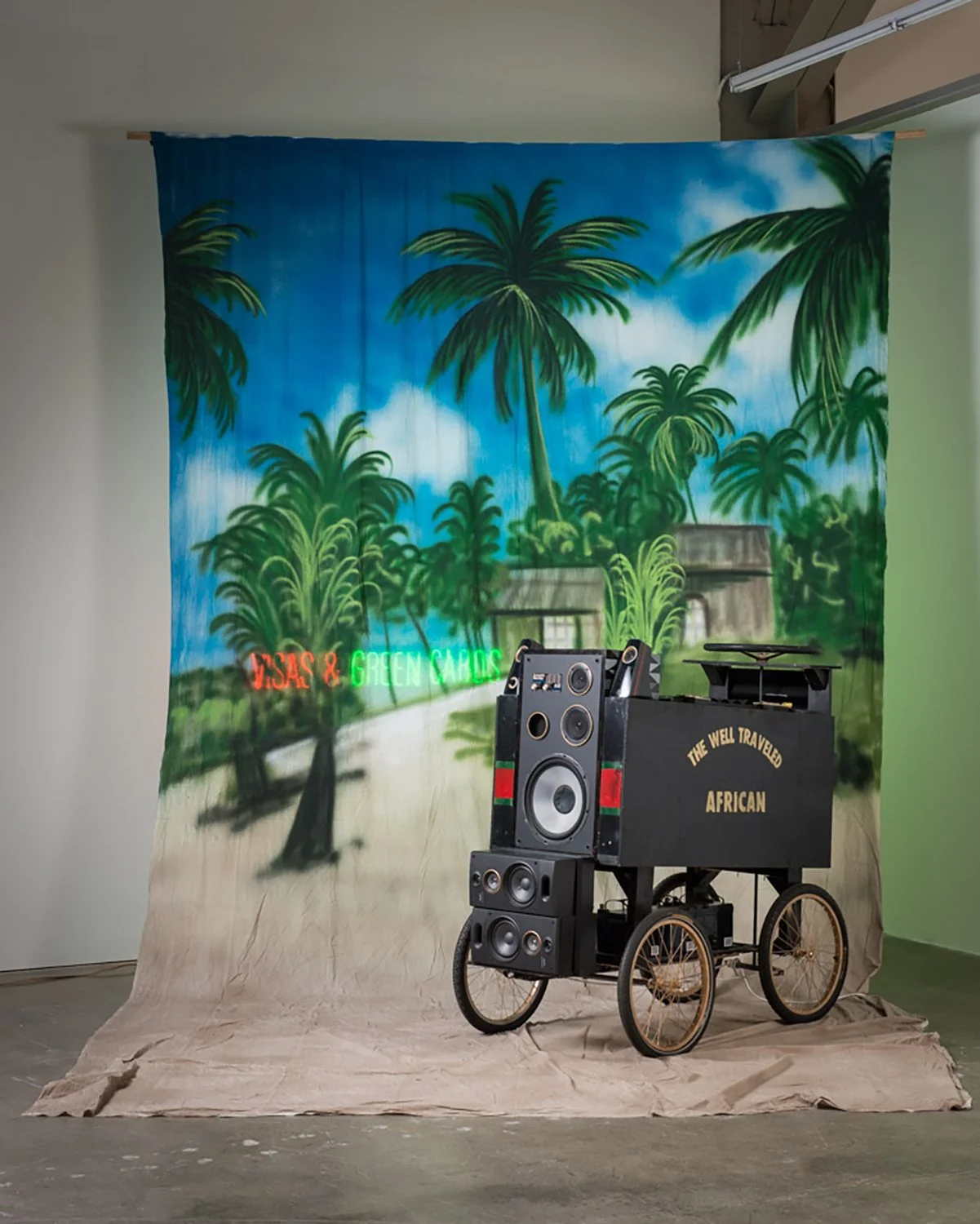 PROMIS(ED) LAND VERSION 3, 2020
Neon Sign, Canvas Backdrop, Reclaimed Shipping Palettes, 4 Bicycle Wheels, Steering Wheel, 5 Speakers, 3 Car Batteries
Size Varies 
