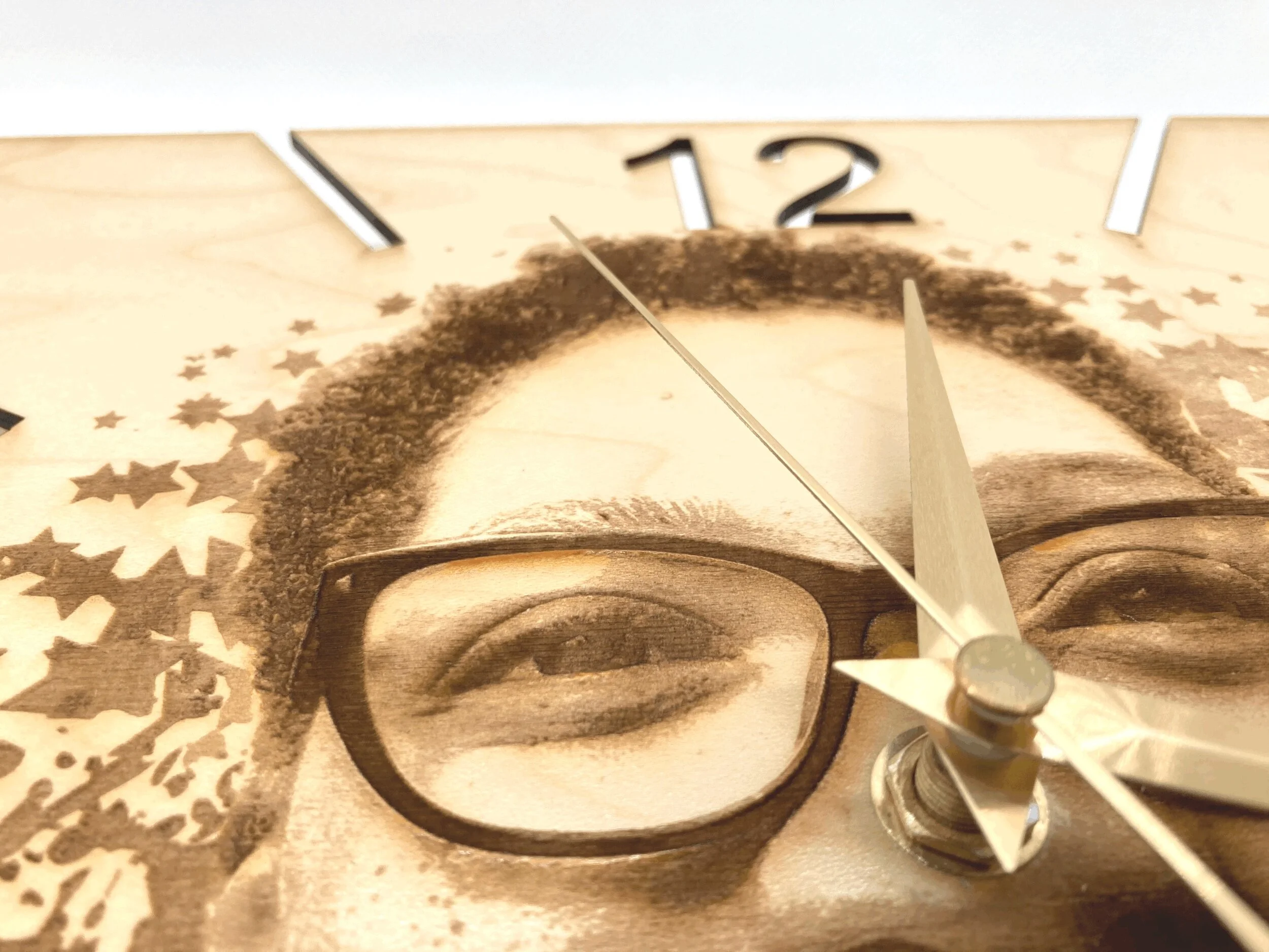 A Kemspora custom art laser engraving, on a uniquely stylish square wooden clock face, of a close up of a woman's head and right eye, who is wearing glasses.