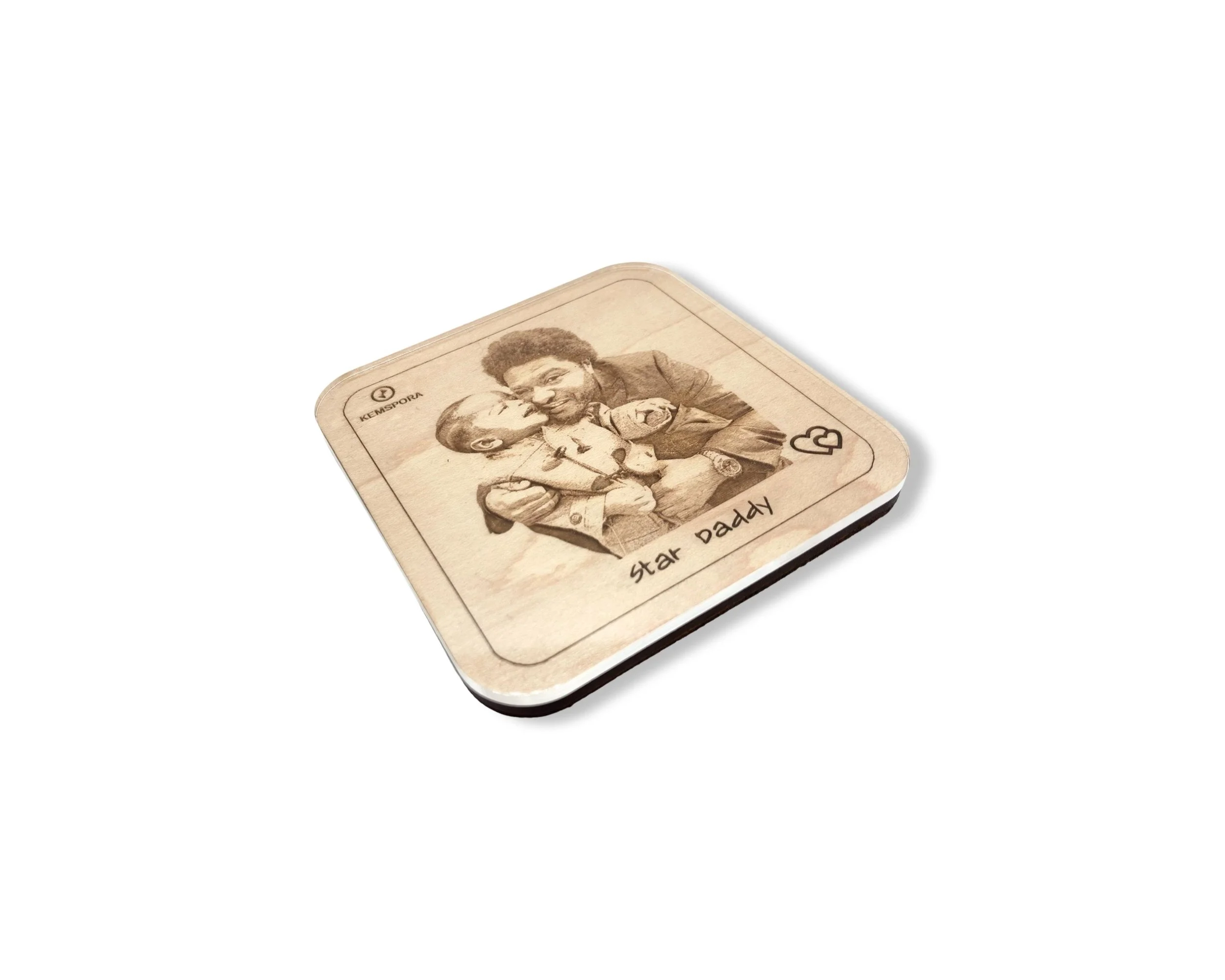 A Kemspora custom art laser engraving, on a uniquely stylish square wooden coaster, of a father hugging his son. Text on coaster reads Star Daddy. Coaster has a clear acrylic covering.