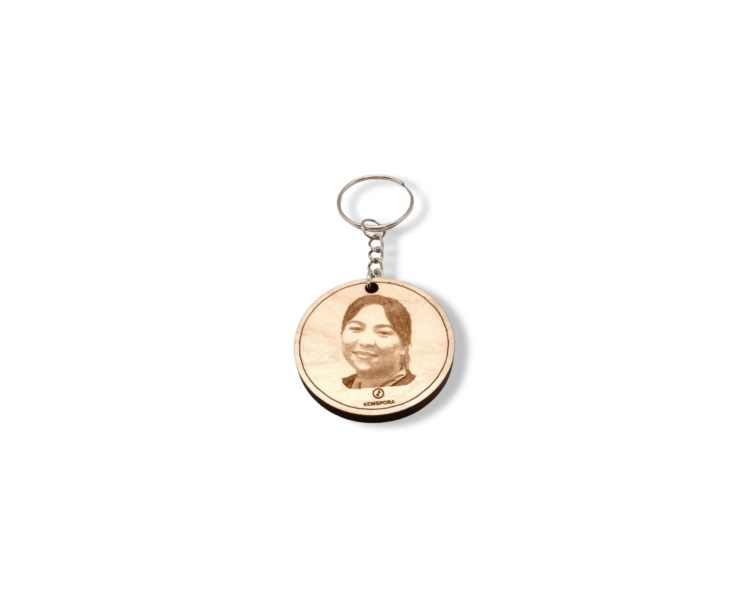 Kemspora custom art laser engraving, on a uniquely stylish circular, wooden, keyring, of a woman with short hair smiling. She is slightly turned to her right.