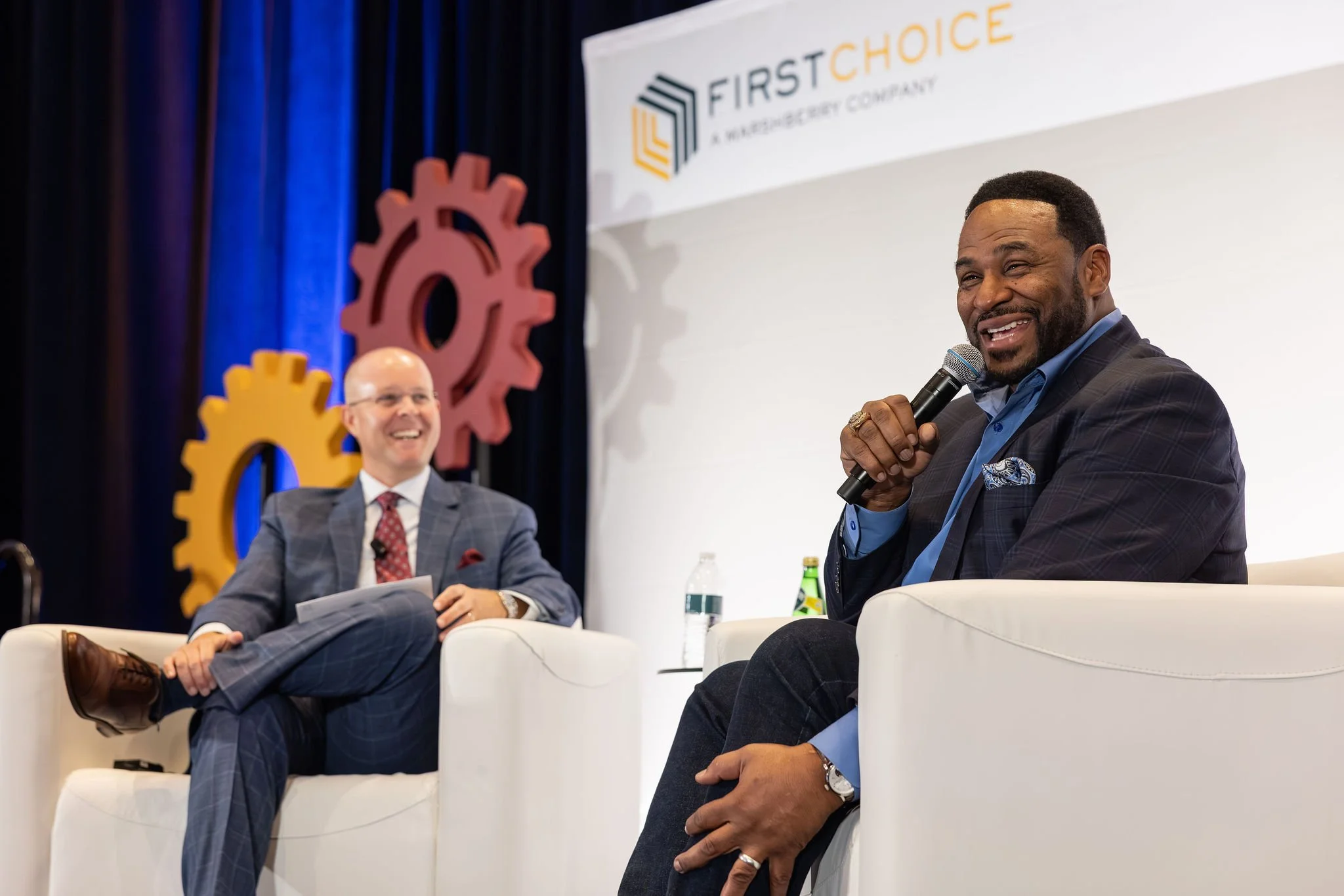 Two speakers in a fireside chat on stage at a FirstChoice corporate conference in Cleveland