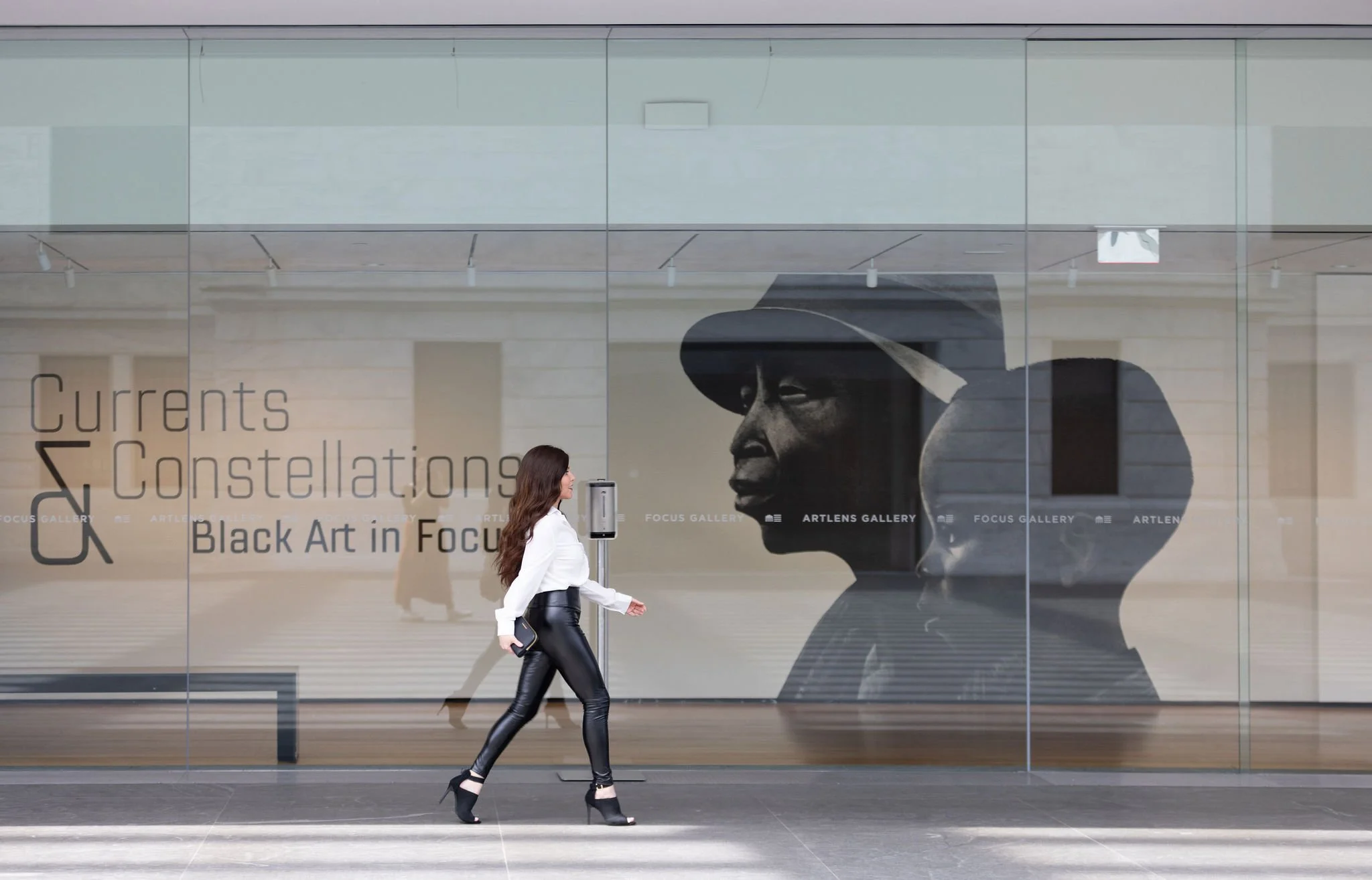Editorial lifestyle photography of a woman walking outside the Cleveland Museum of Art, capturing natural movement and modern branding imagery.