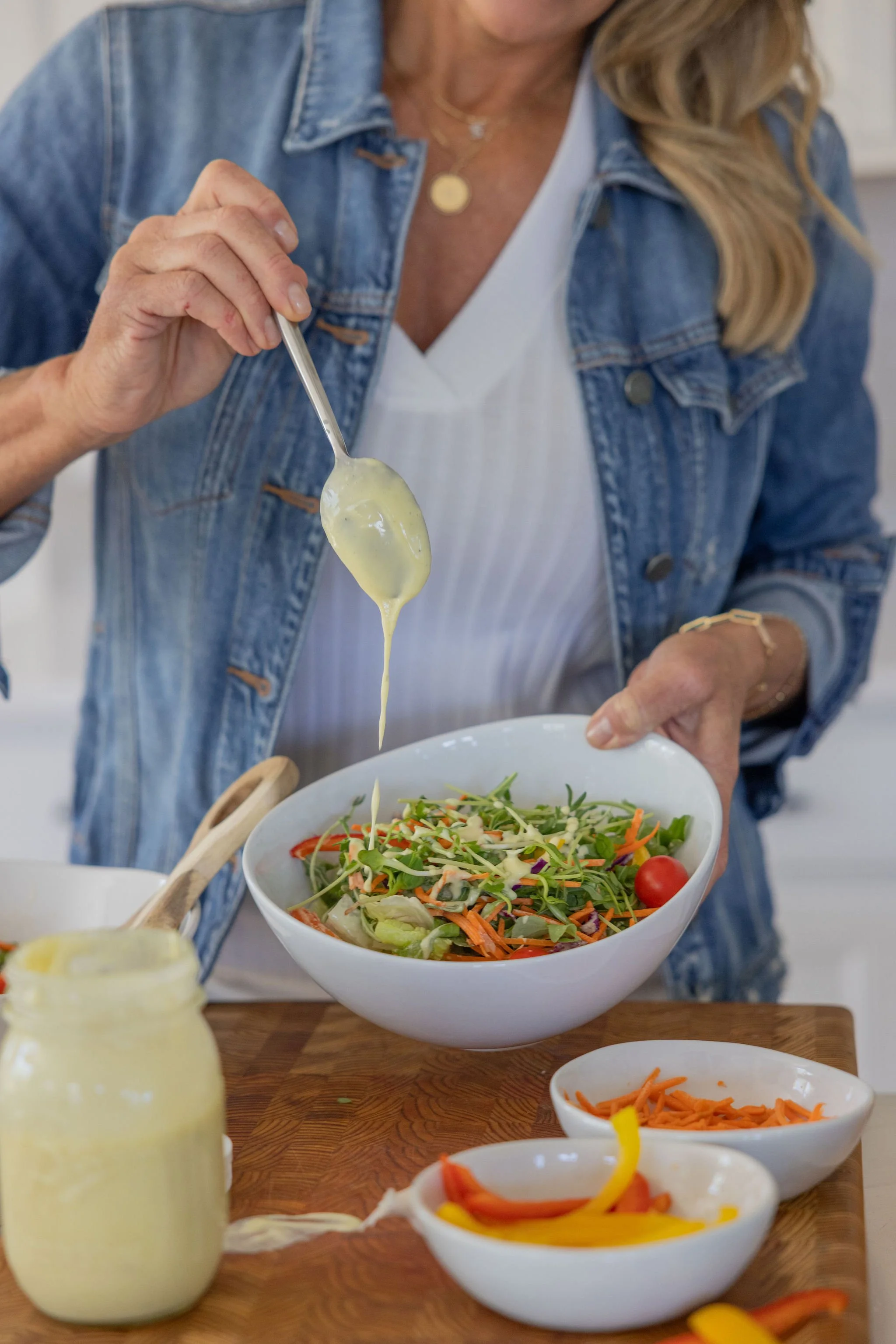 Woman drizzling dressing over a fresh salad during a Cleveland personal branding photo shoot
