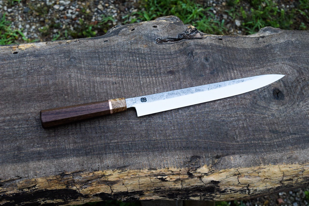  240mm Hidden-Tang Yanagiba with Forge Finish. Octagonal Walnut Handle with a Maple Burl Ferrule and a Copper Spacer. 