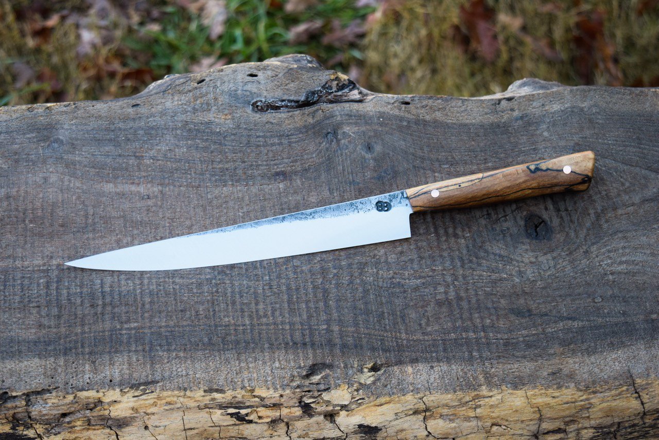  8.5” Full-Tang Slicer with Forge Finish. Western Spalted Copper Beech Handle with Brass Pins.  