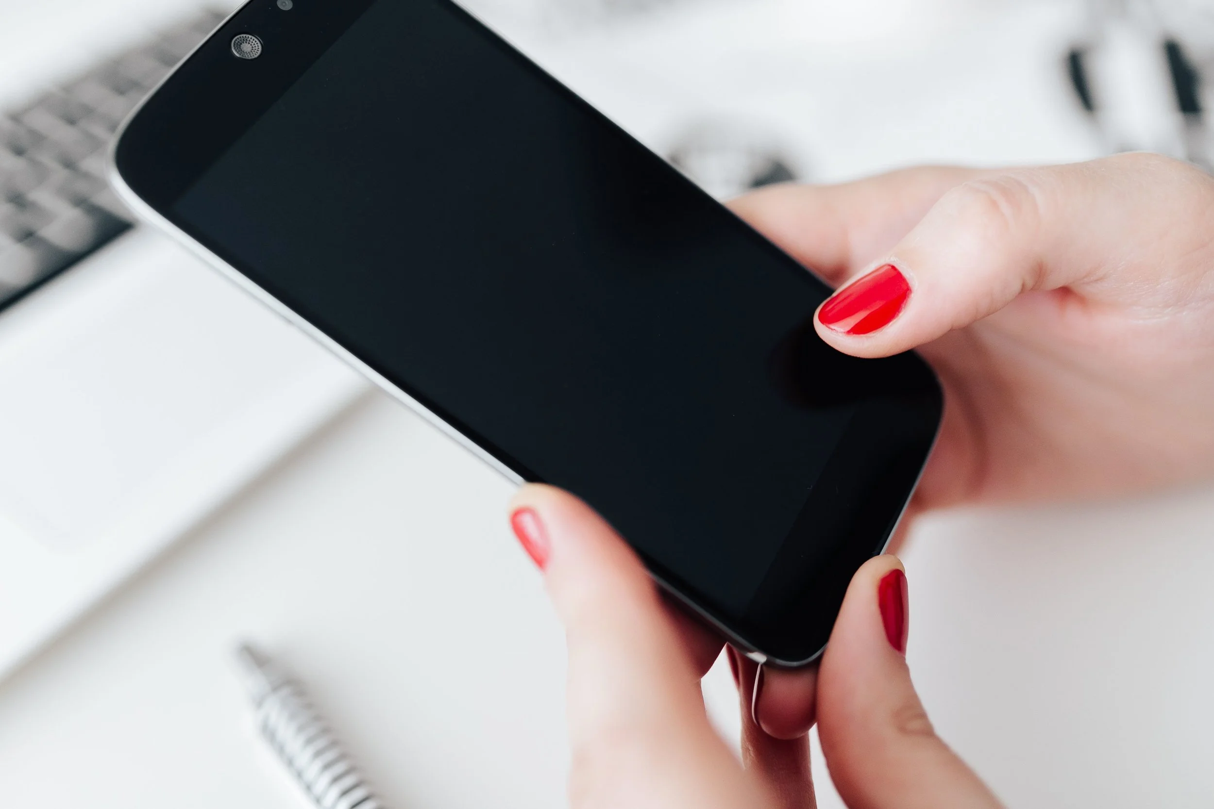 kaboompics_Businesswoman uses her mobile phone at her desk.jpg
