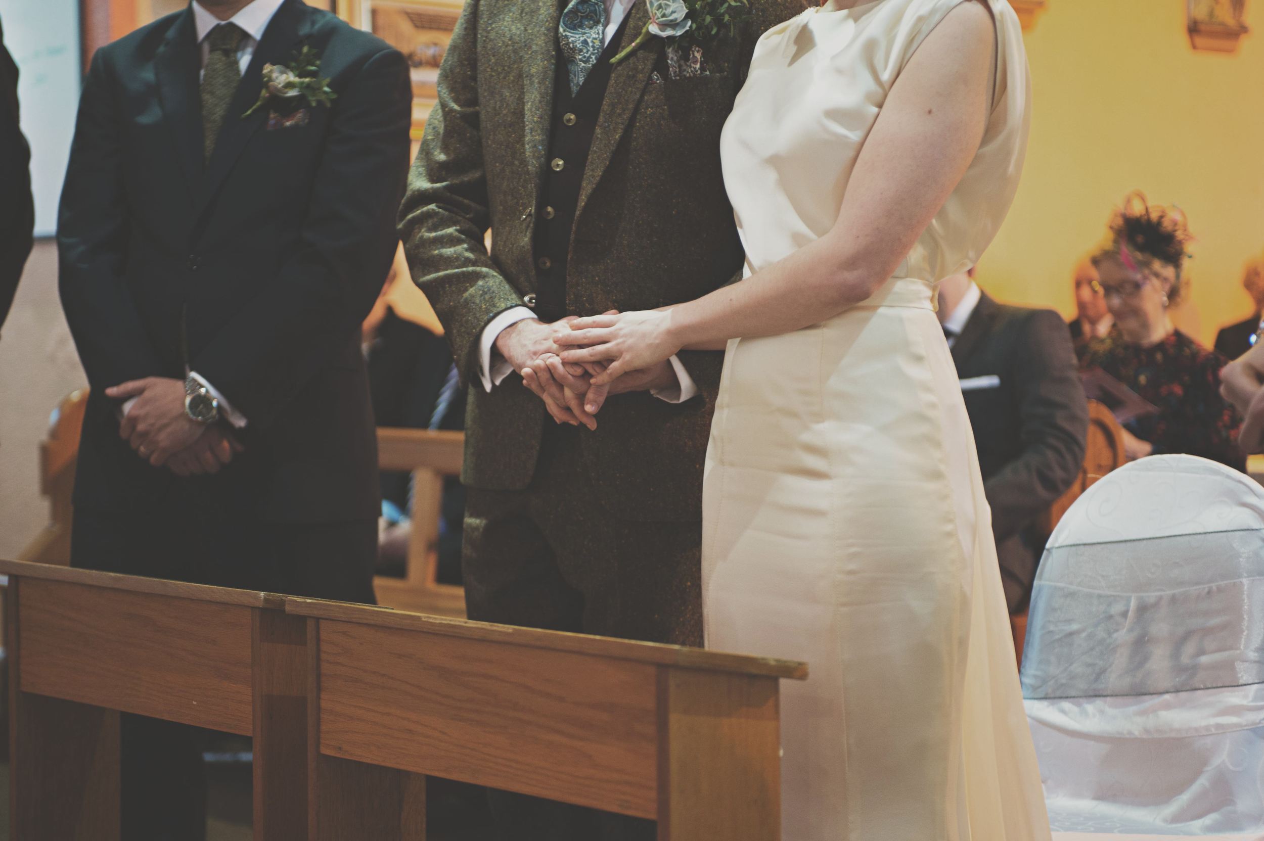 Holding hands at wedding service