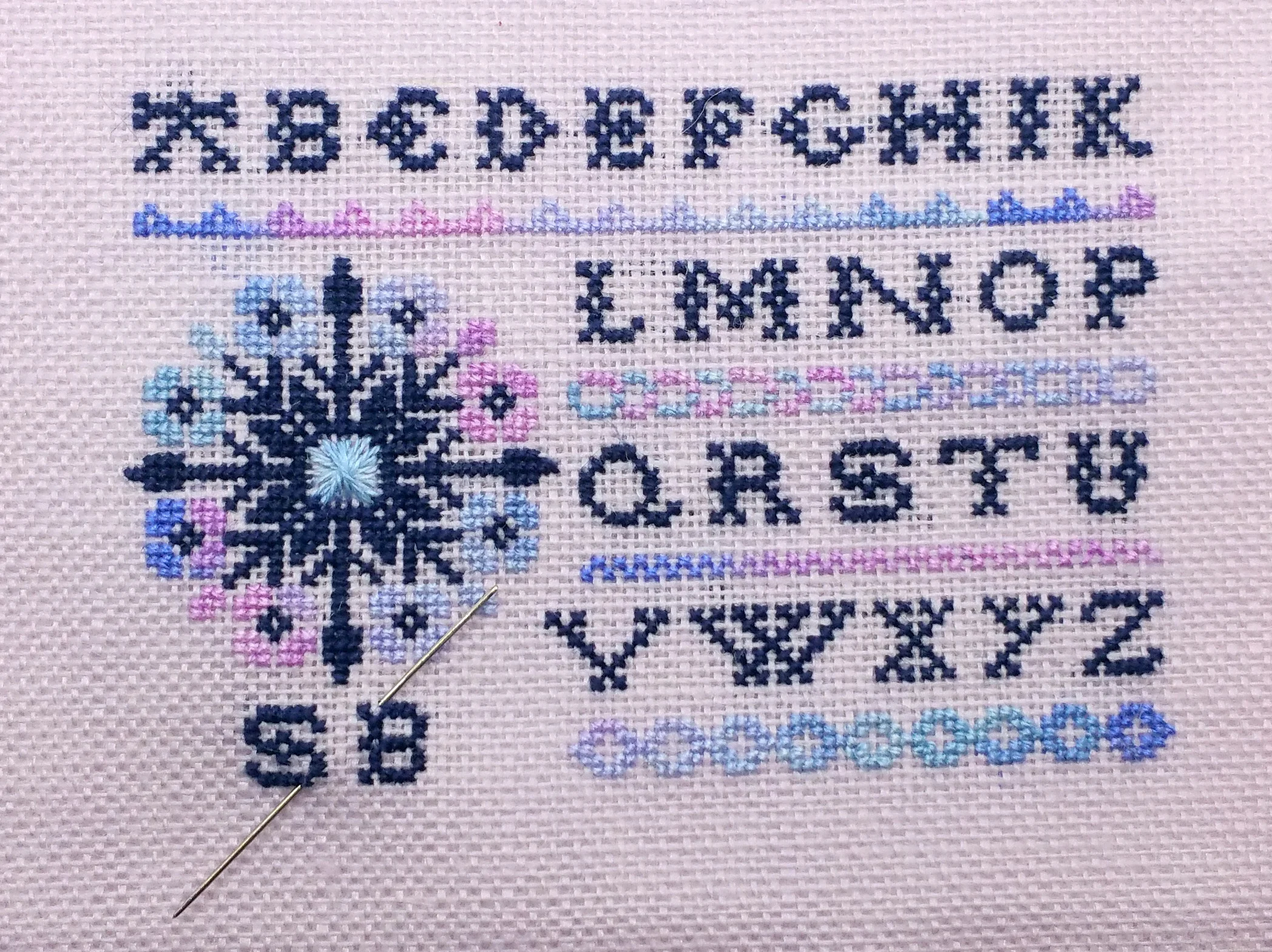 So teeny, so tiny! Our version of Threadwork Primitives' Primrose Sampler is stitch over 1 on 32 count linen. That's a 28 count needle for scale!