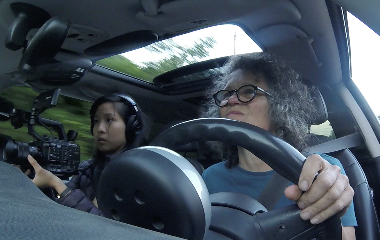 Rachel, artchange intern, and ellen, 14 miles instigator, driving from one end of sitka to aother to see if it is truly 14 miles from END TO END. in sitka, ak.