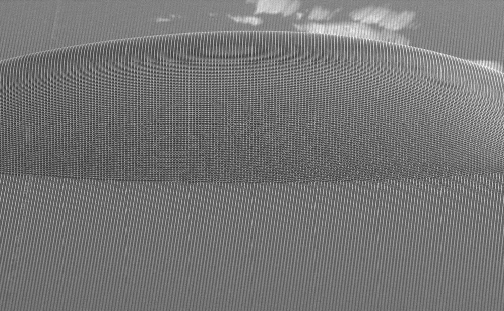 A bubble between a UV-cured grid pattern and its polycarbonate backing