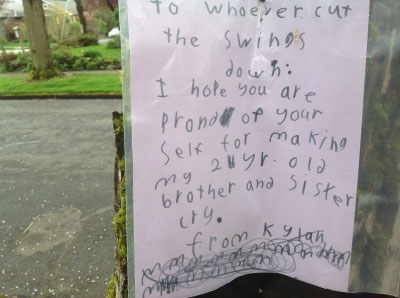 The sign reads, "To whoever cut the swings down: I hope you are proud of your self for making my 2 year old brother and sister cry. From, Kylan"