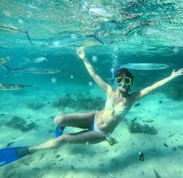 Charlotte dealing with the common traveller problem of when your new underwater mates try and photobomb your photo all at once