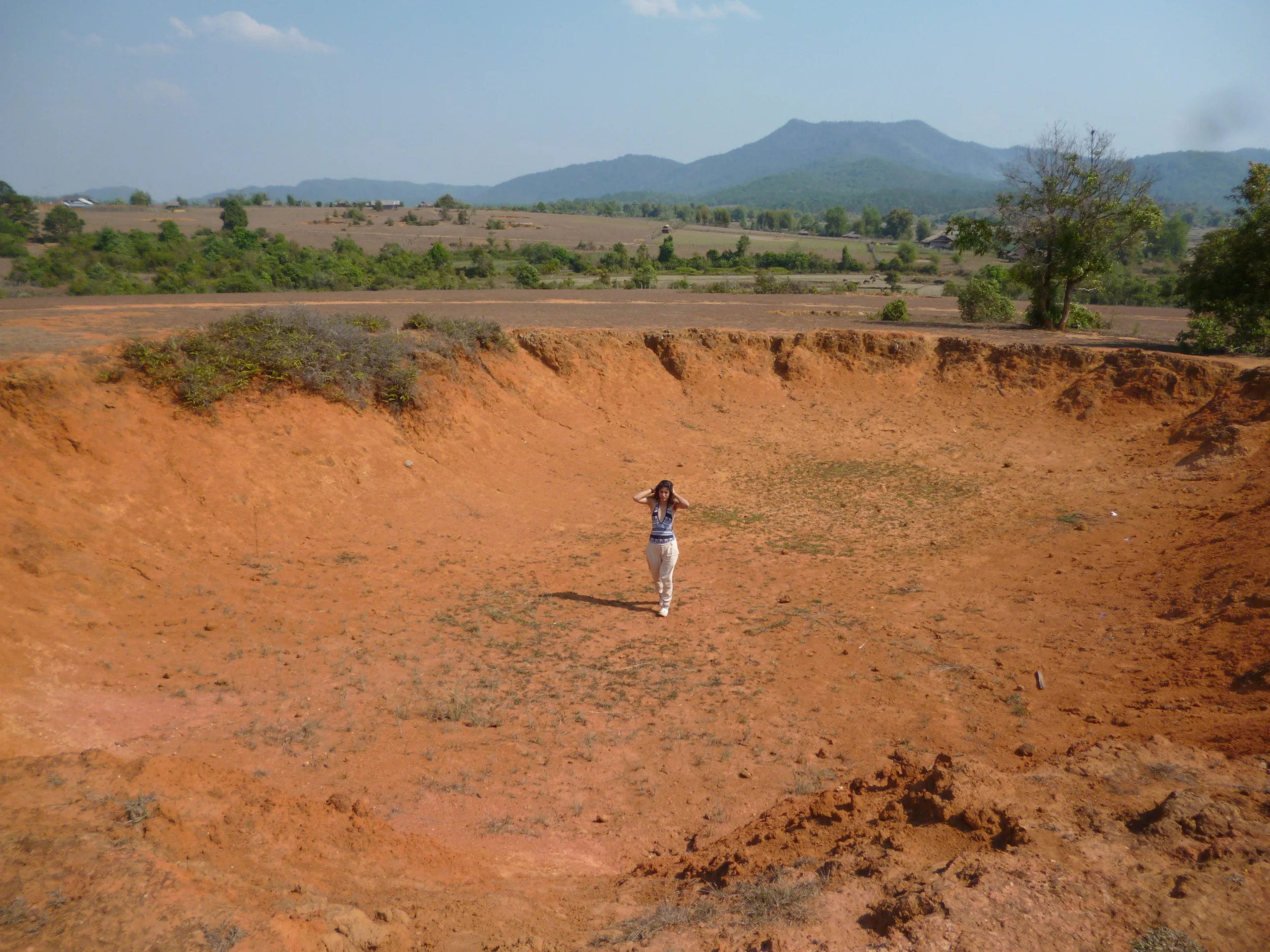 Dilara exploring a bomb crater she found near the Plain of Jars, Laos