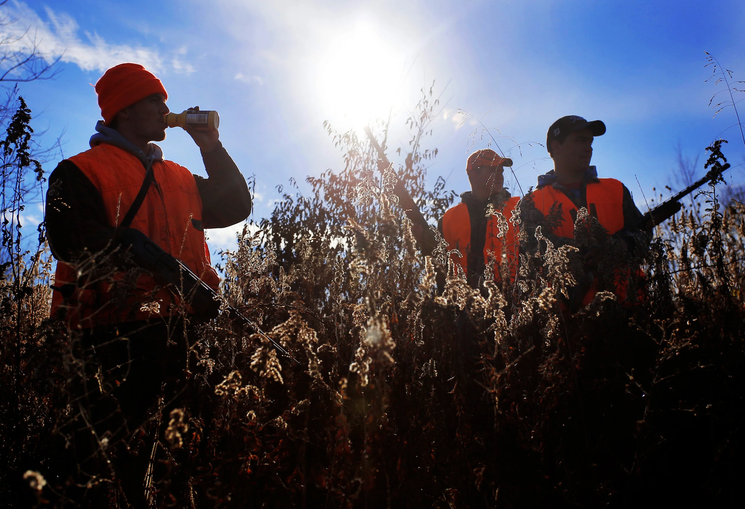 Jacob Koons drinks some milk while taking a break with Bryce Smathers, center and Reed Morgan while rabbit hunting in a field outside of Millfield, Ohio, on November 11, 2014.