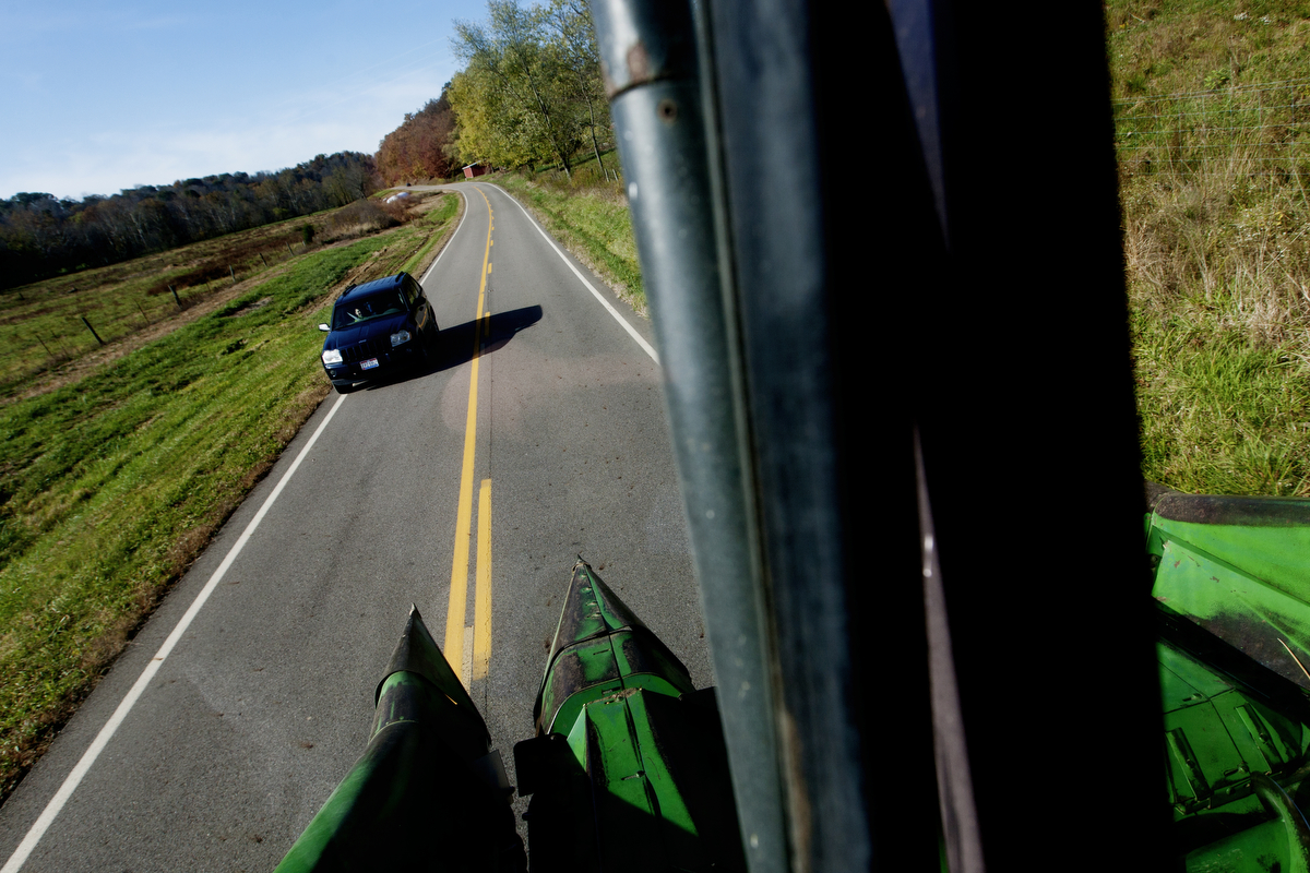  Paul Southall slowly drives his combine down a rural highway on his way to harvest a field of corn. 