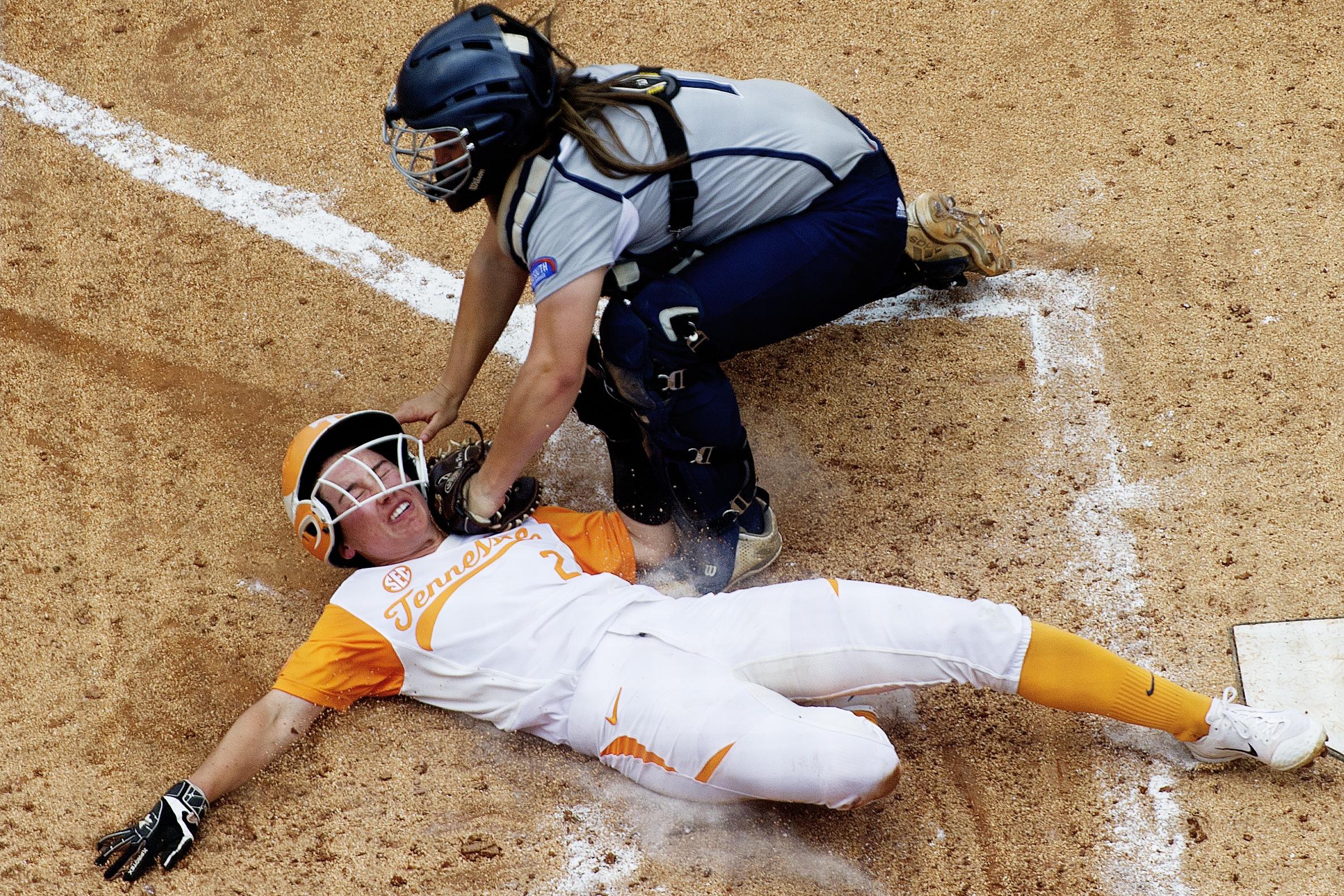  Tennessee’s Jenna Holcomb (2) slides into home as Longwood’s Kaylynn Batten (1) tags her out during a game between Tennessee and Longwood. 