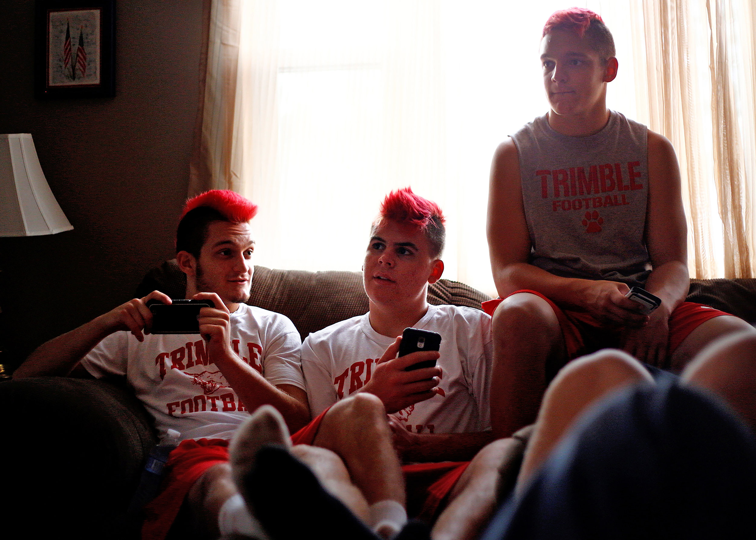 Austin Downs, Micah Couch and another teammate hang out at home after Trimble High School football practice in October 2014.